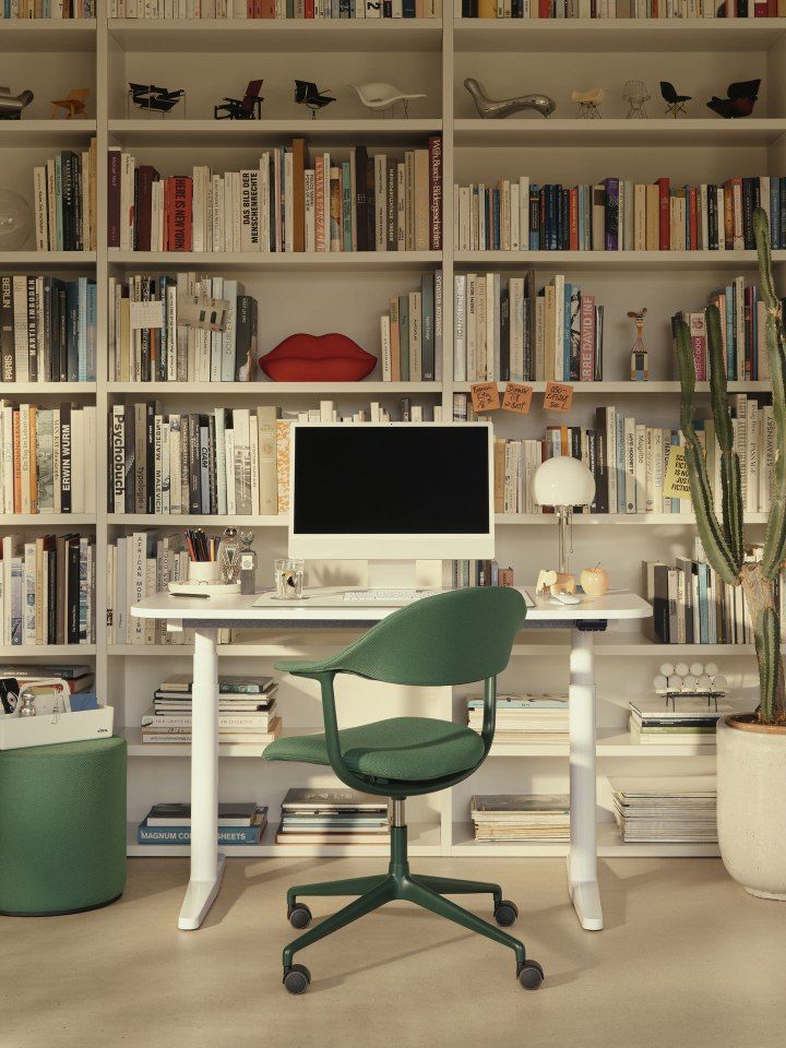Mynt Bürodrehstuhl von Vitra, grüner Drehstuhl mit Kunststoff Rückenlehne und Sitzfläche vor Bücherregal.
