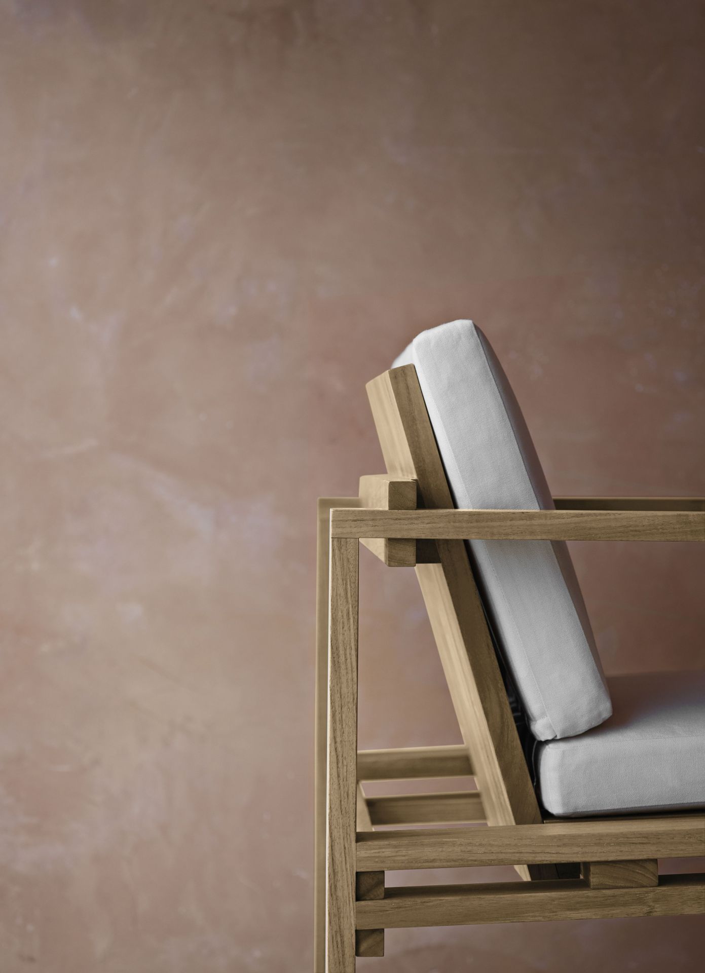 Detailaufnahme des Bodil Kjaer Outdoorstuhls von Carl Hansen & Søn mit hellgrauen Polstern.
