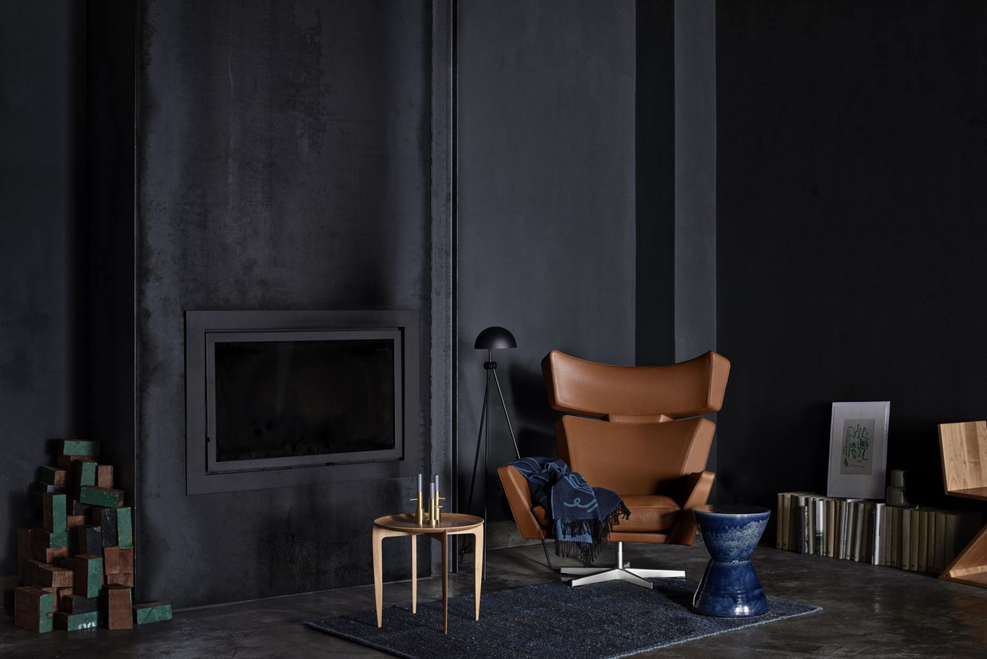 Oksen Sessel von Fritz Hansen in braunem Leder mit Decke in dunklem Wohnzimmer.