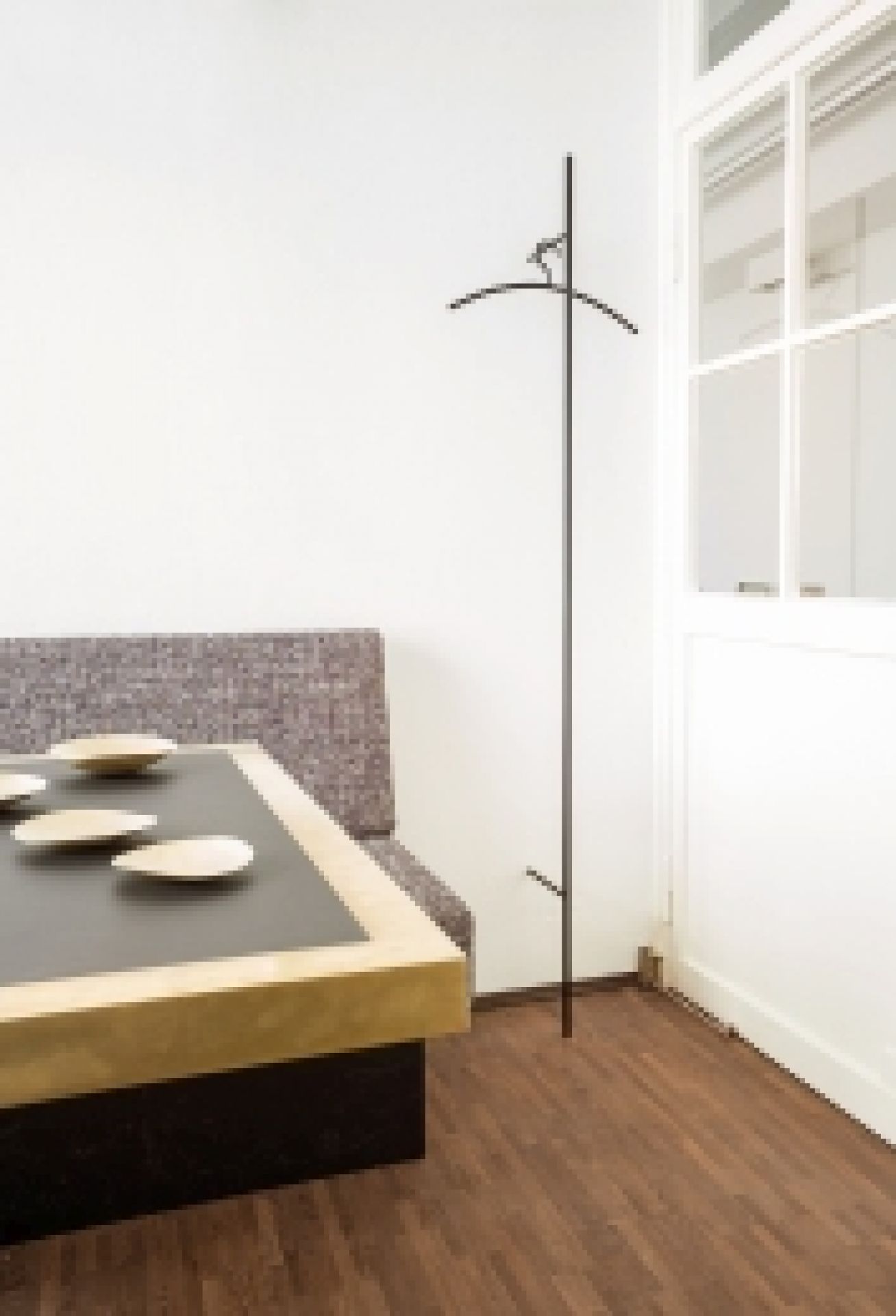 Schwarze, minimalistische Schönbuch Wandgarderobe "Sketch" im Flur vor weißer Wand und Tür. Design Garderobe für Jacken.
