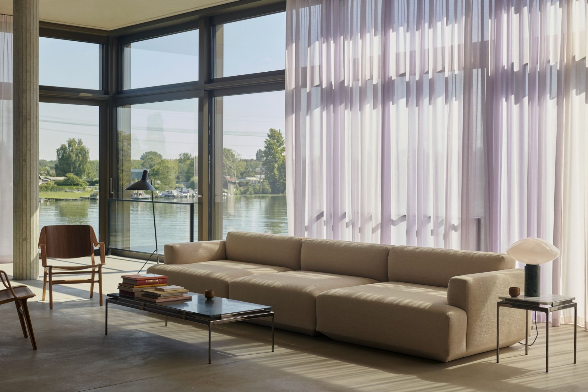 AndTradition Sett LN12 Couchtisch im modernen Wohnzimmer mit Sofa, Stühlen und Seeblick.
