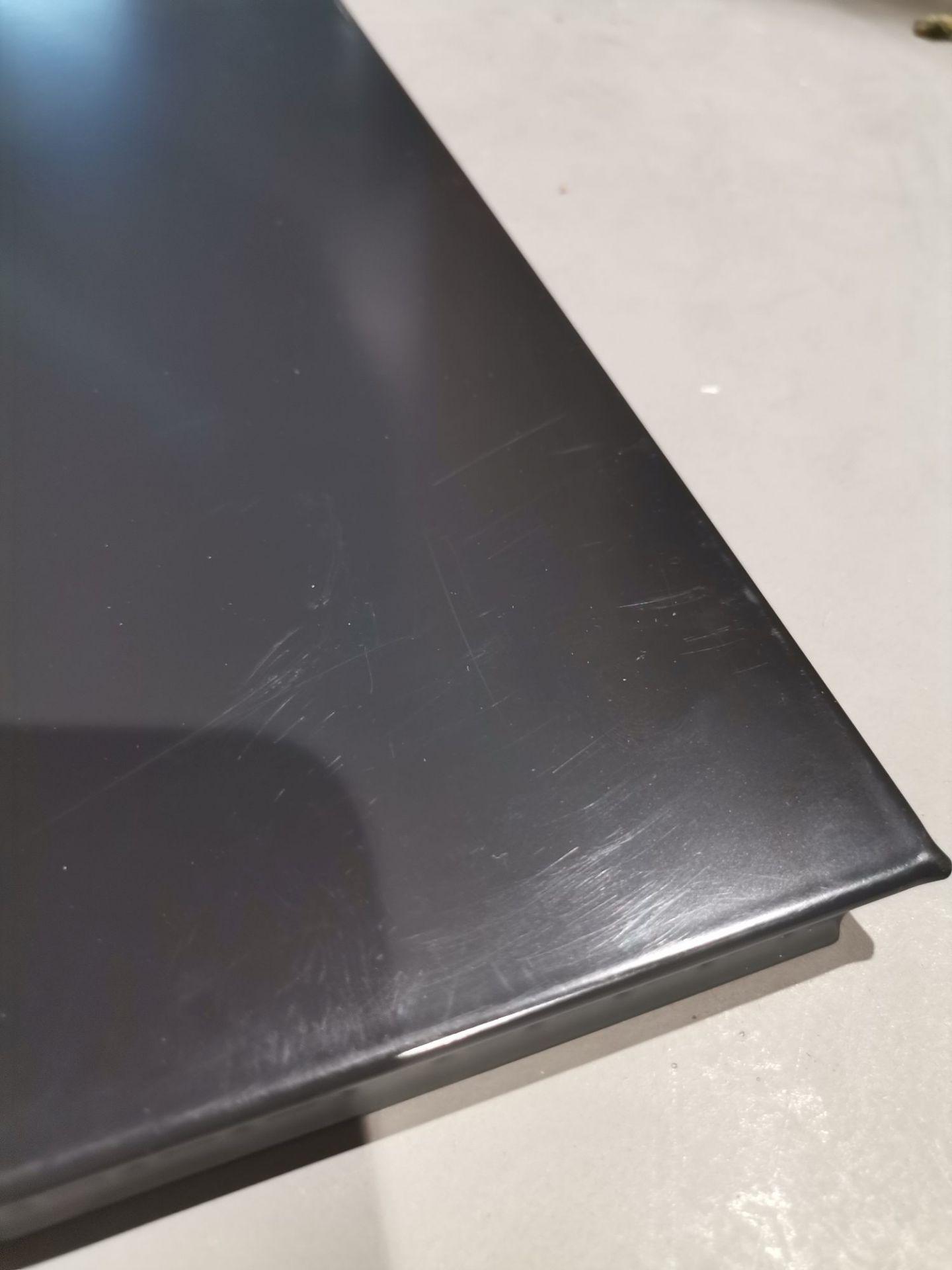 Detailaufnahme einer schwarzen USM Haller Tischplatte mit Kratzern, ein Mängelexemplar für Ersatzteile.