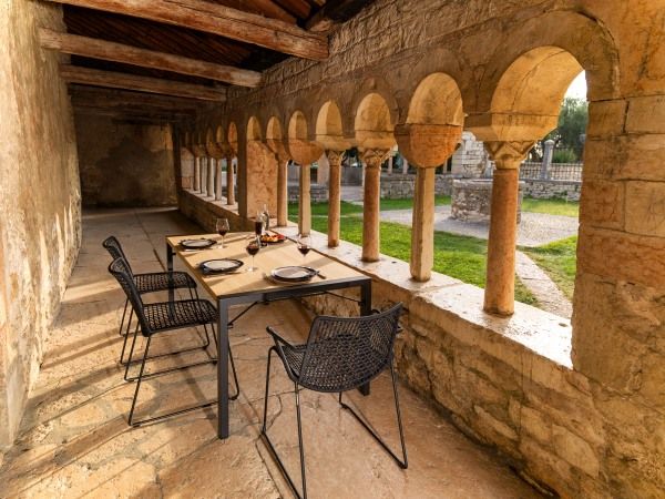 Slope Tisch von Weishäupl: Outdoor Esstisch mit schwarzen Stühlen in historischer Umgebung.