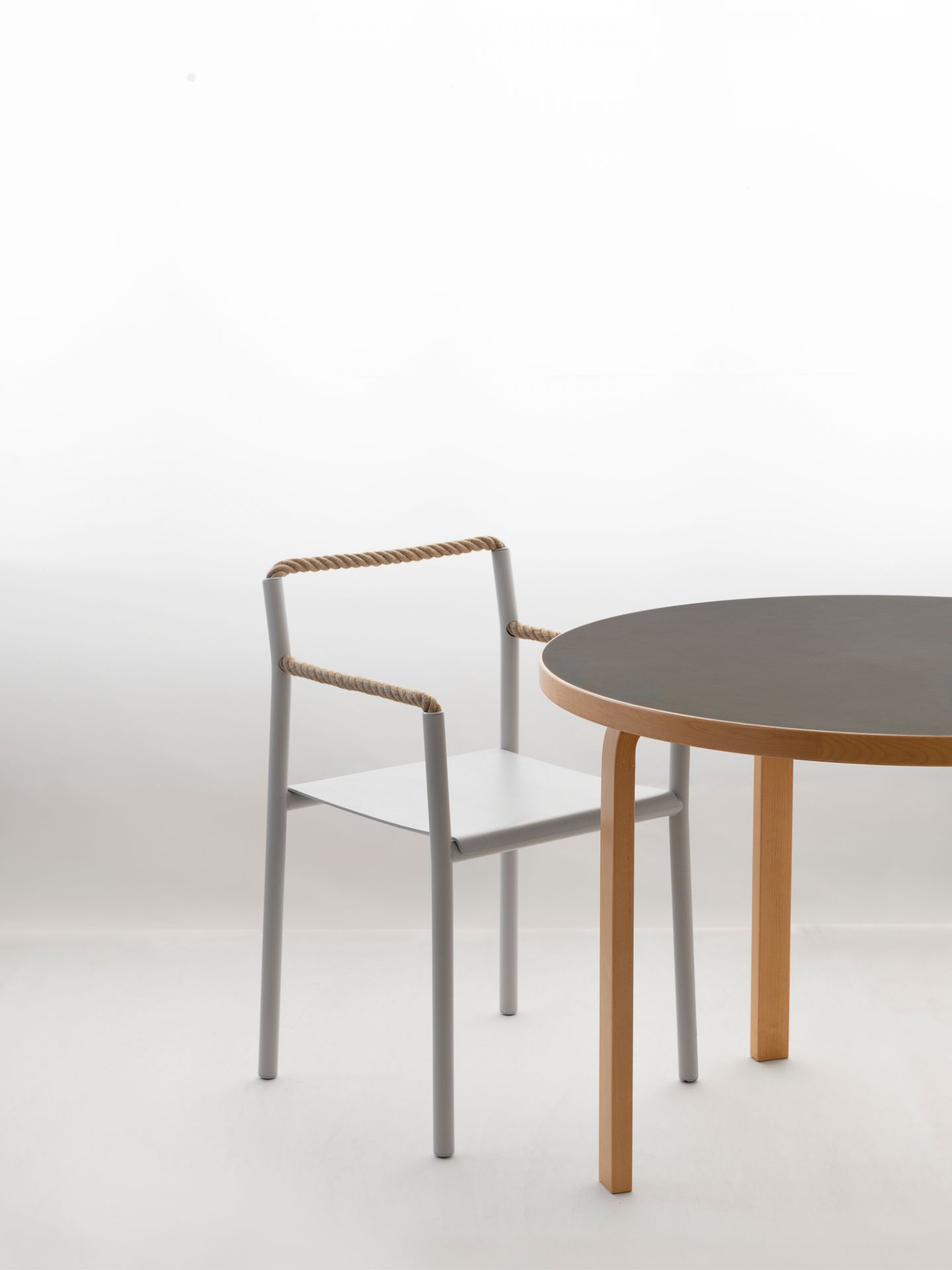 Artek Rope Chair: Moderner Stuhl mit Seildetails und minimalistischem Design neben einem Holztisch.