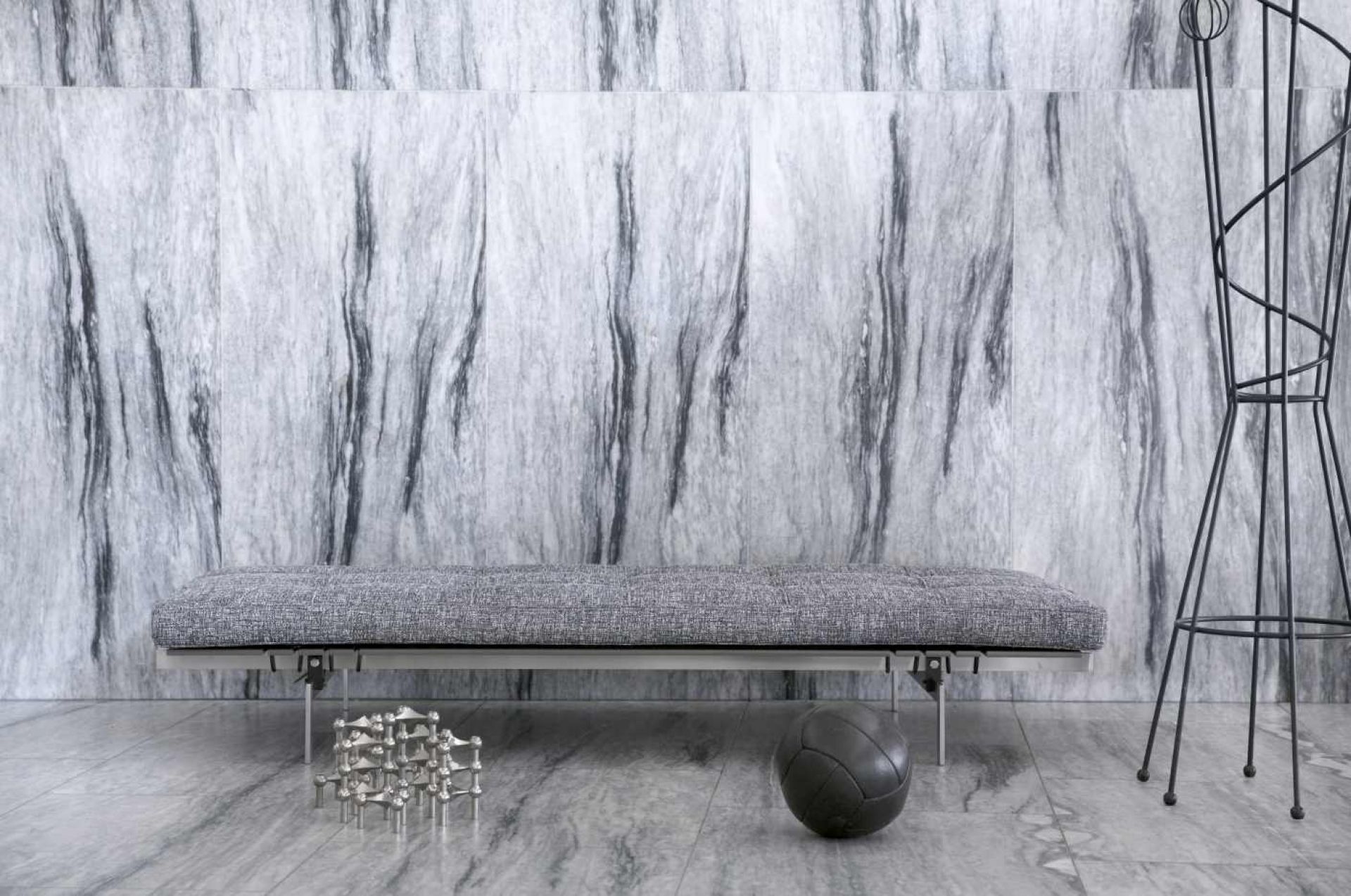 Graue PK 80 Liege von Fritz Hansen vor einer Marmorwand, modernes Designmöbel für Wohnzimmer und Lounge.