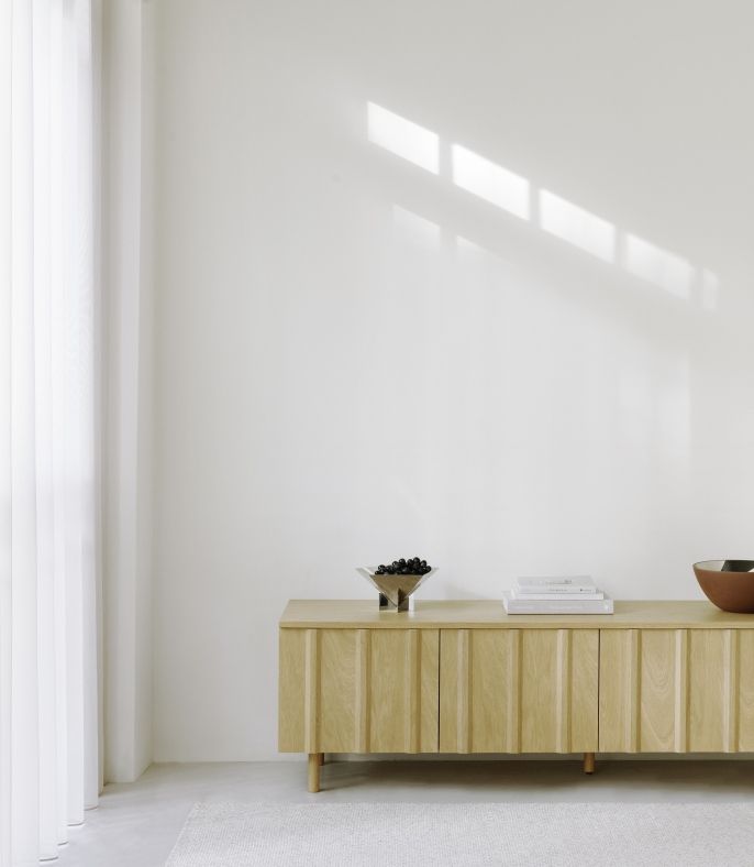 Fem Schale von Normann Copenhagen aus Edelstahl auf einem Sideboard mit Deko-Objekten in minimalistischem Interieur.