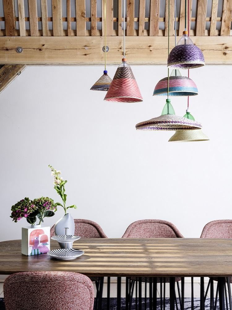 Esstisch mit Ona 2020 Curved Armchair Stühlen von Freifrau Manufaktur und bunten Stroh-Hängelampen.
