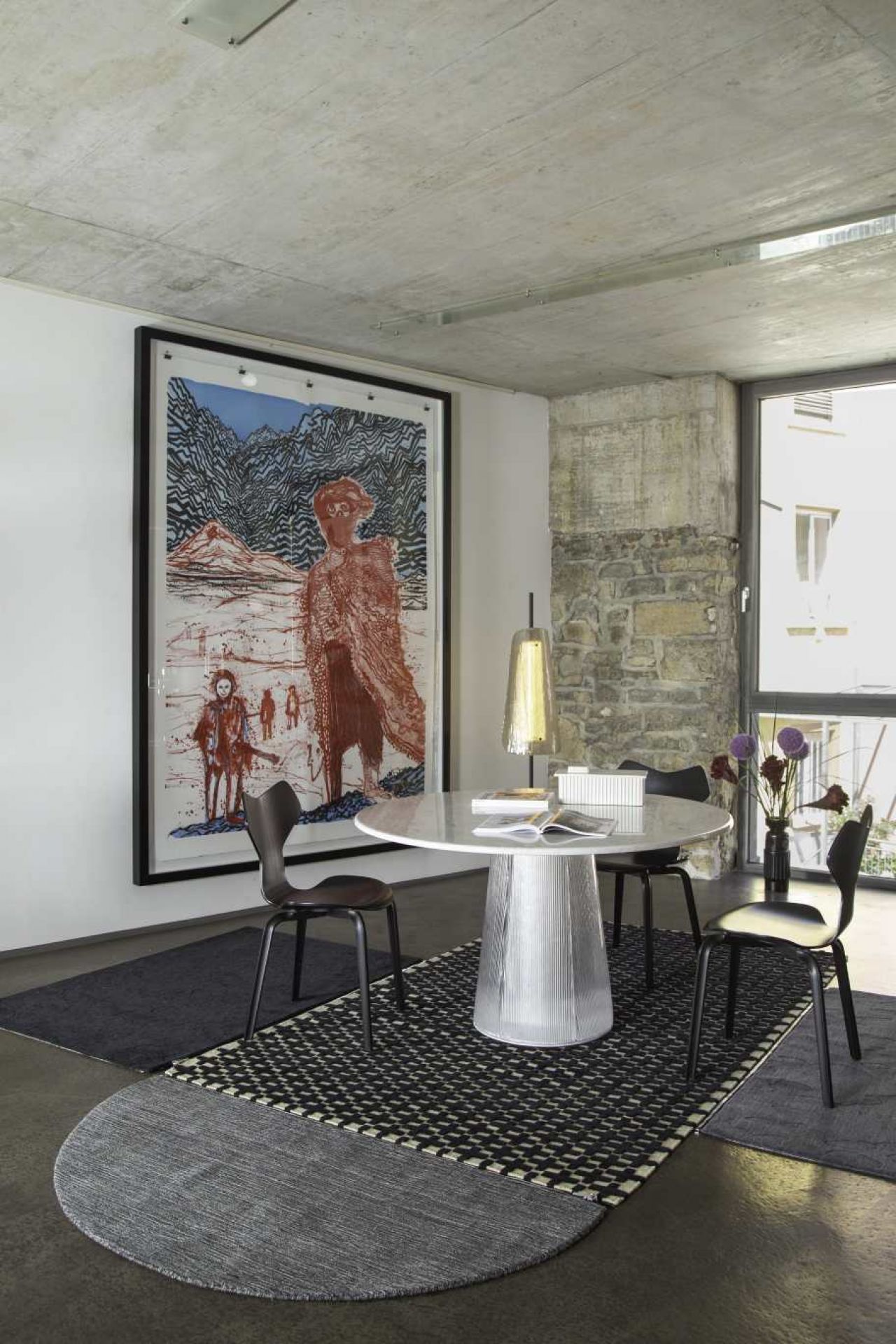 Esszimmer mit rundem Bent Esstisch von Pulpo, Stühlen und Kunstwerk an der Wand.