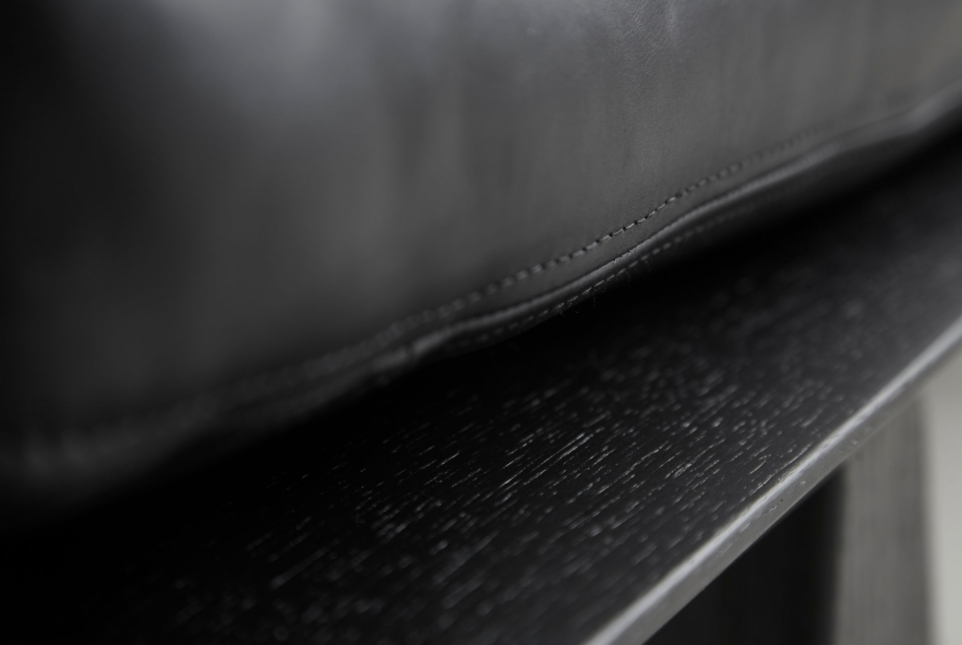 Detailaufnahme: Schwarze Level Daybed Liege von Woud mit Lederpolsterung und Holzrahmen.
