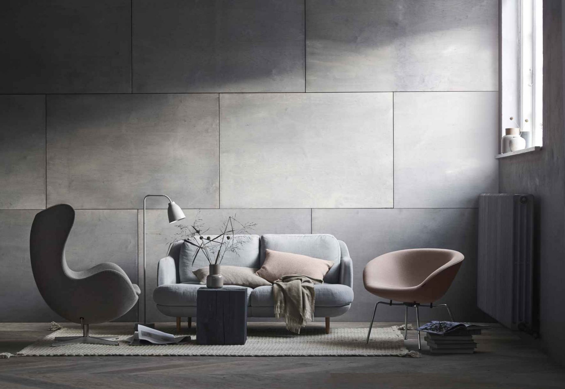 Wohnzimmer-Szene mit grauem Lune Sofa von Fritz Hansen, Sessel und Design-Stuhl.