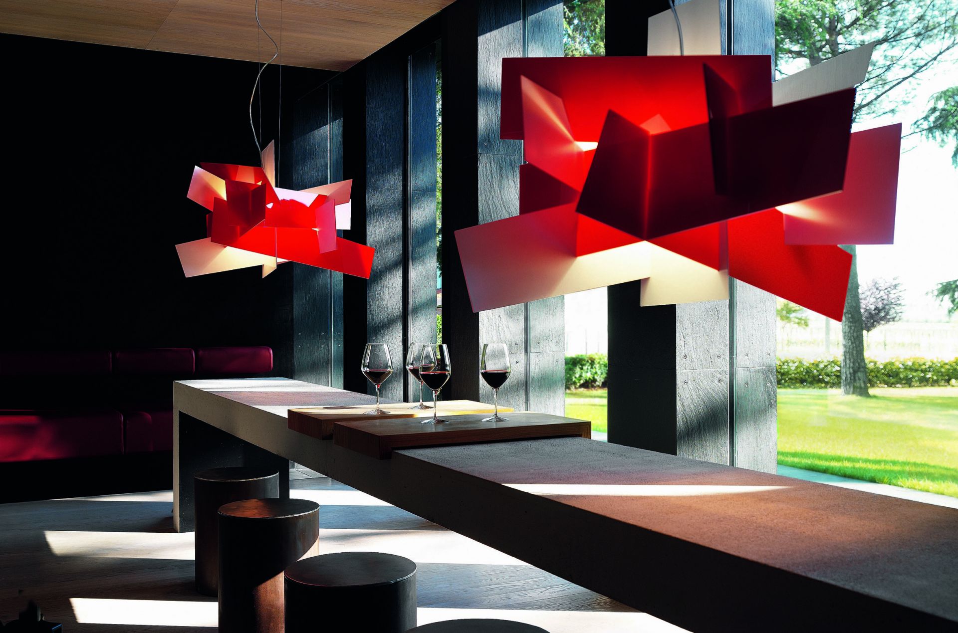 Rote Big Bang Hängeleuchte von Foscarini über einem Tisch mit Weingläsern. Design Lampe.