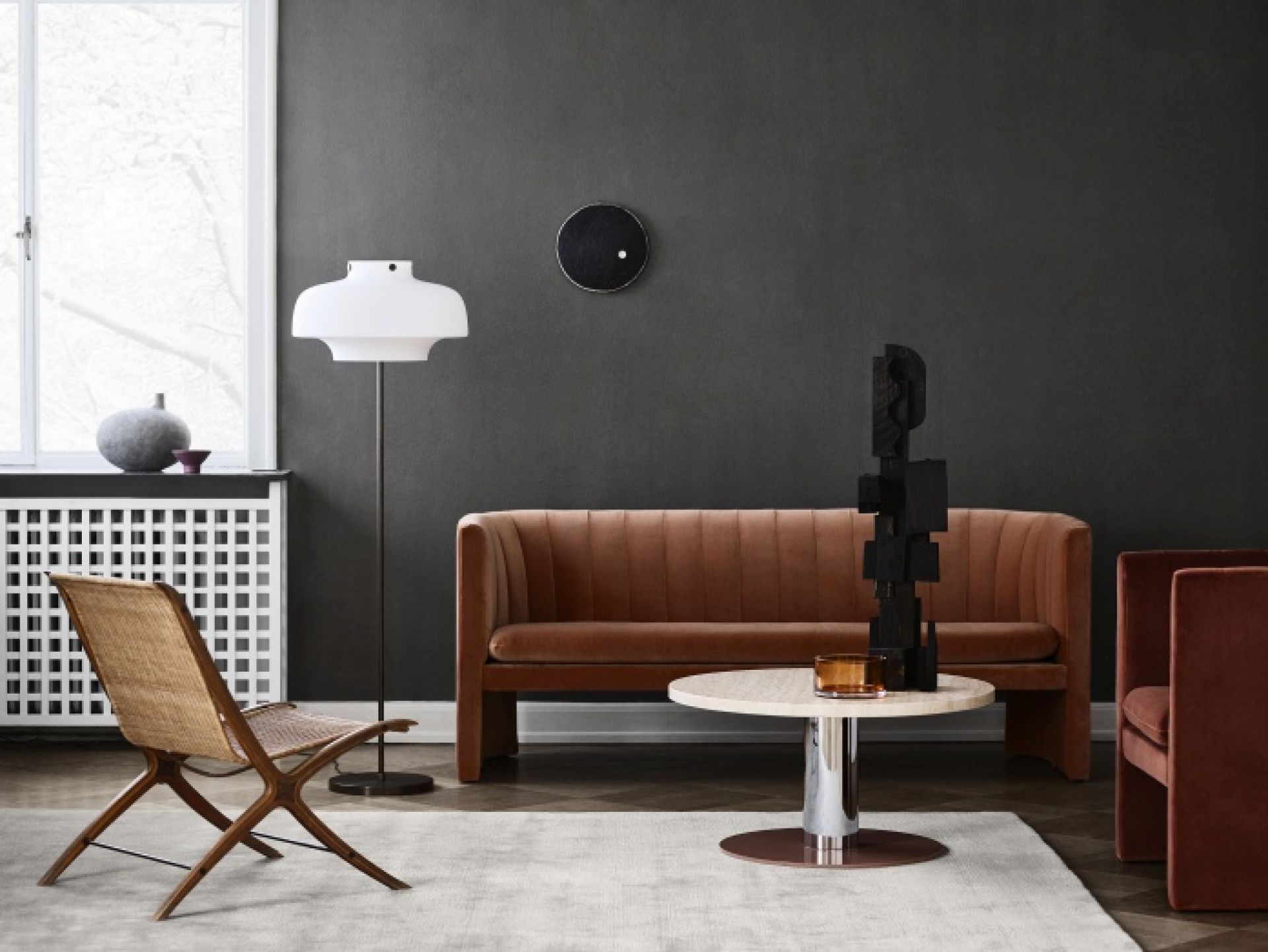 Heller The Moor Rug Teppich von AndTradition in einem Wohnzimmer mit braunem Sofa und Sessel.