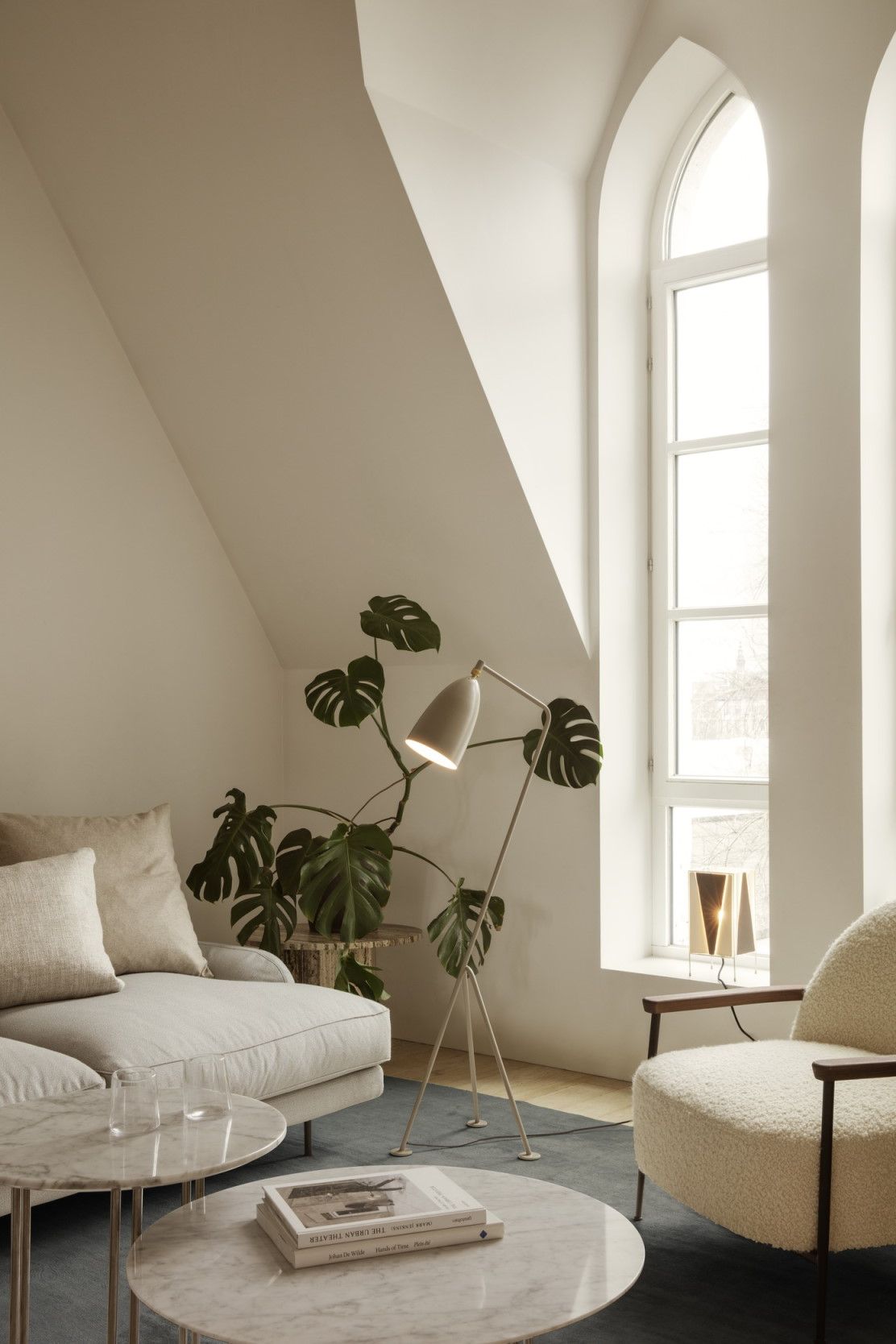 Wohnzimmer mit Epic Coffee Table Couchtisch von Gubi, Sofa, Sessel und Stehlampe.