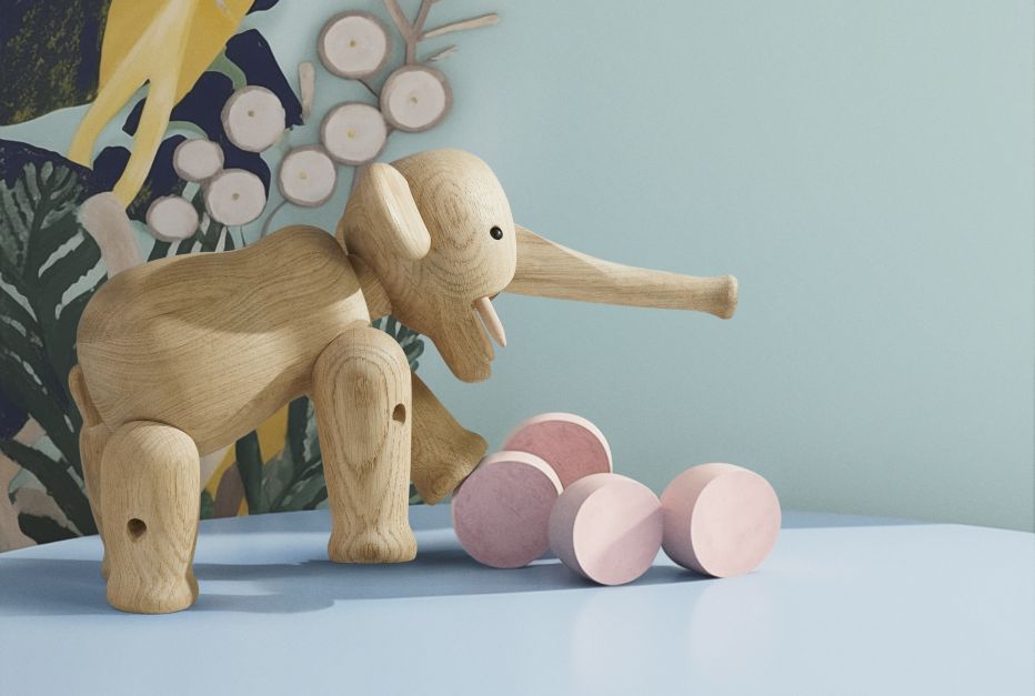 Grosser Kay Bojesen Elefant aus Eichenholz mit beweglichen Gliedmaßen und rosa Holzkugeln auf blauem Untergrund.