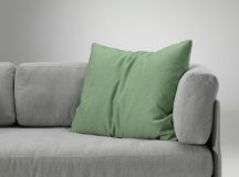 Grünes Vitra Kissen auf einem grauen Sofa, modernes Sofakissen für Wohnzimmer und stilvolle Dekoration.