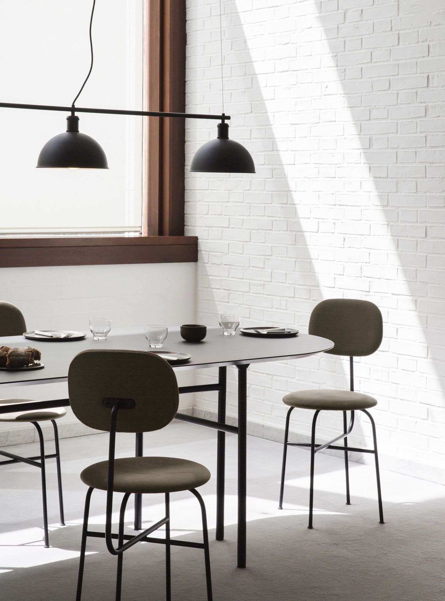 Afteroom Dining Chair Plus von Audo Copenhagen am Esstisch mit Geschirr und Pendelleuchten.