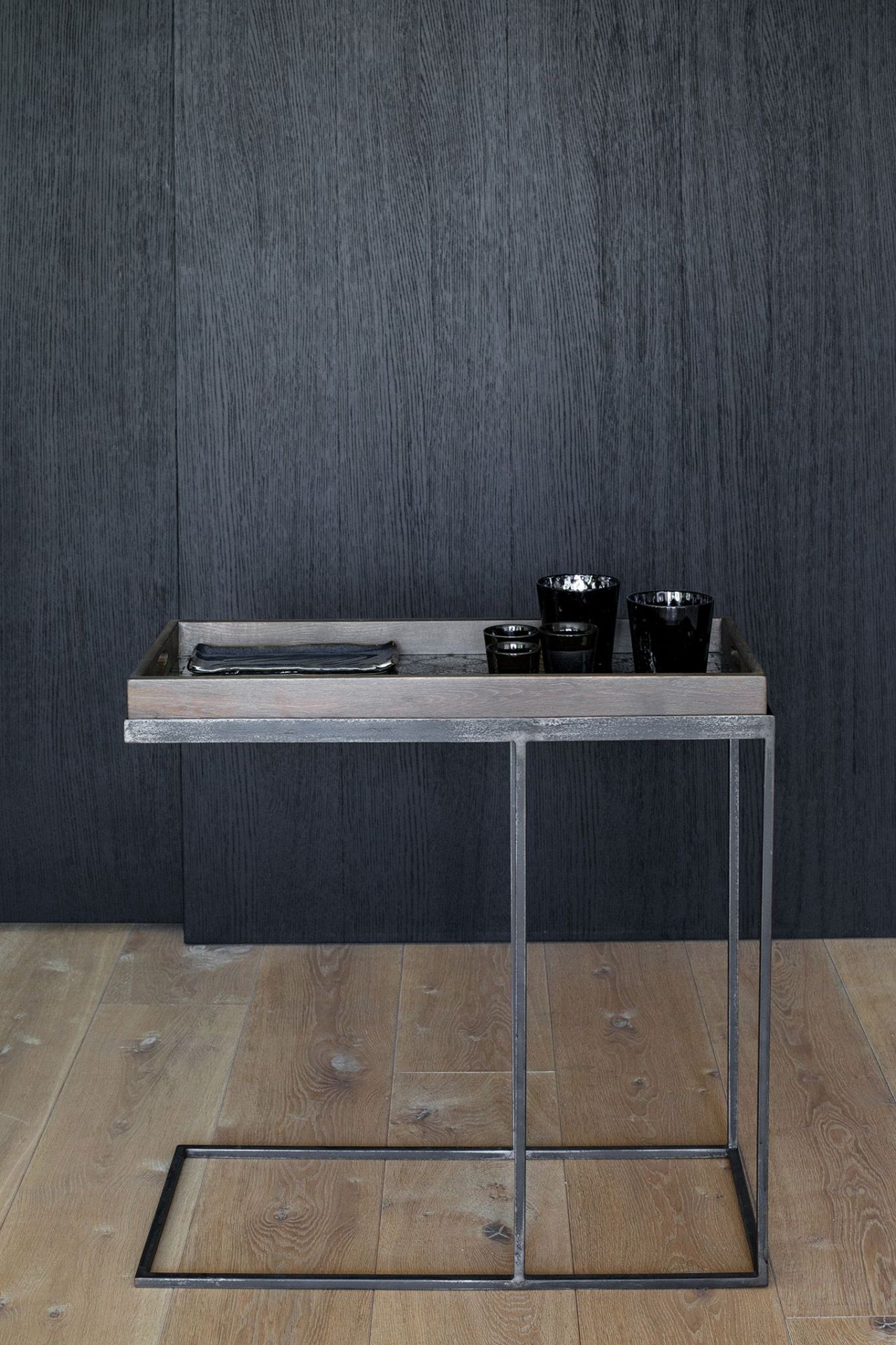Ethnicraft Beistelltisch aus Holz, schwarz lackiert, mit Tablett und schwarzen Gläsern auf Holzboden.