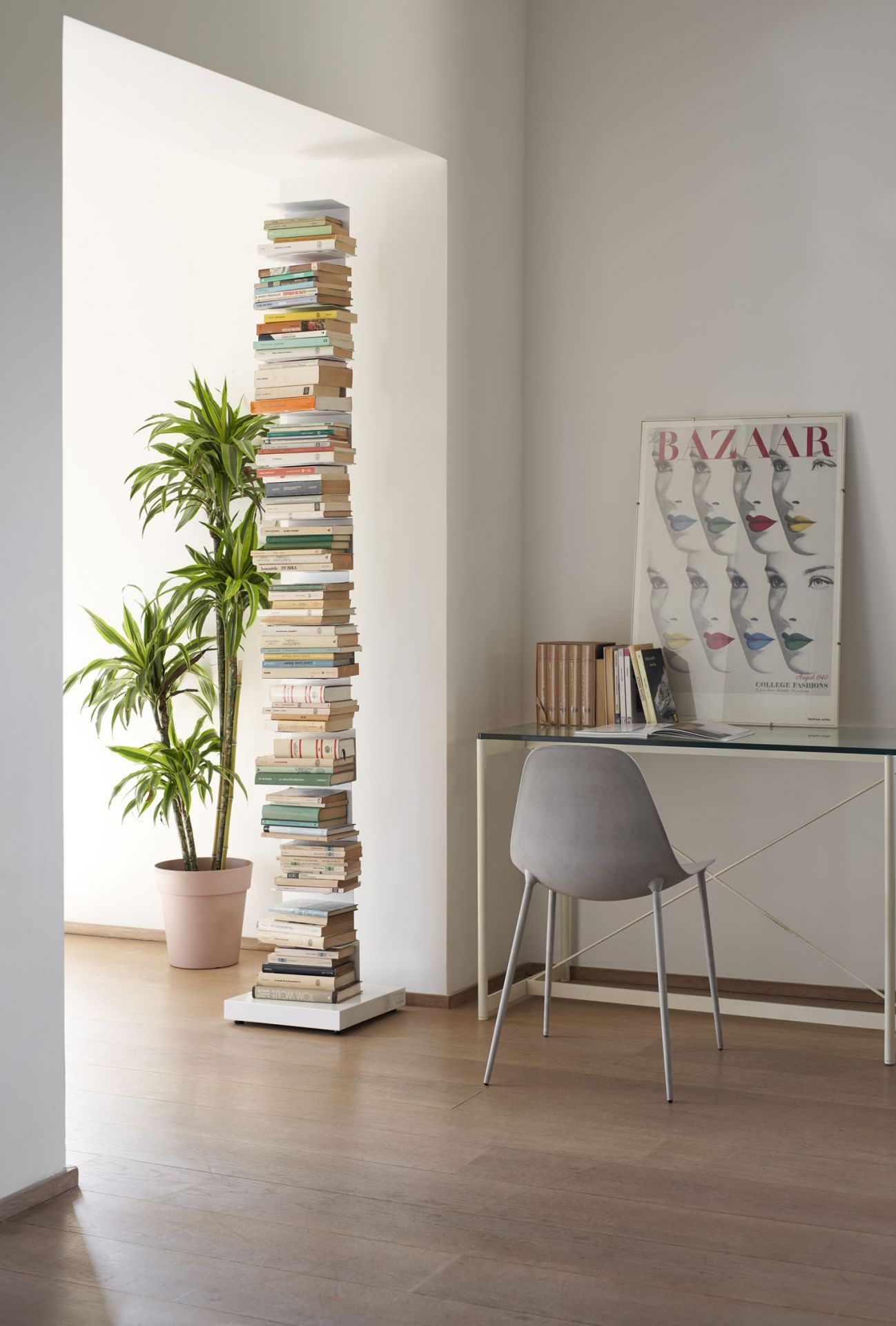 Ptolomeo Bücherregal freistehend in Weiß, gefüllt mit Büchern, neben einer Zimmerpflanze im modernen Wohnzimmer.