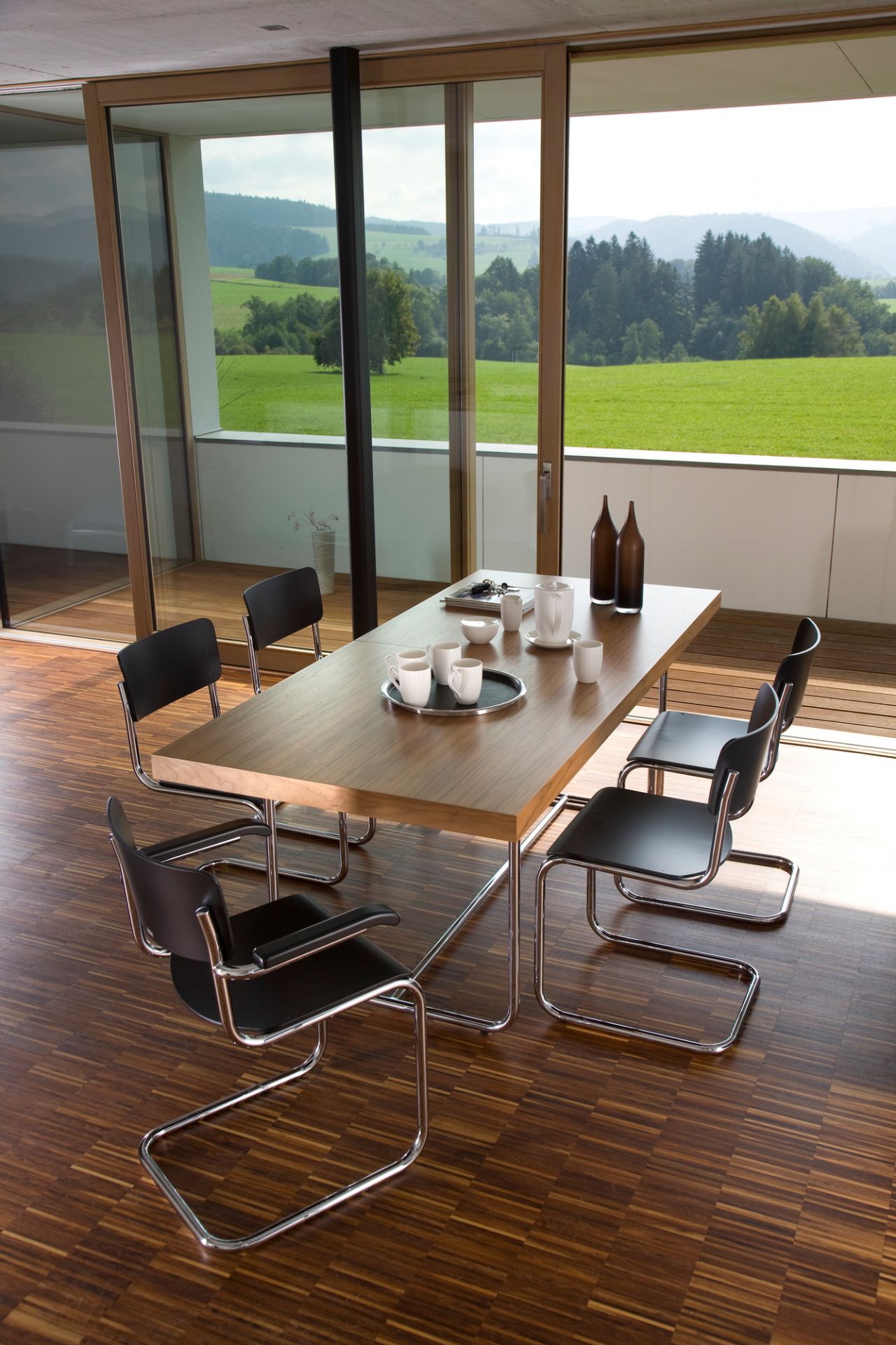 S 43 F Freischwinger von Thonet: Schwarzer Buche-Stuhl mit Stahlrohr-Gestell und Chrom vor Panoramafenster.