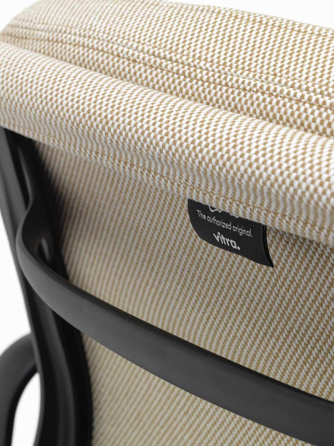 Detailaufnahme des Soft Pad Chair EA 231 von Vitra mit beigem Stoffbezug und schwarzem Rahmen.