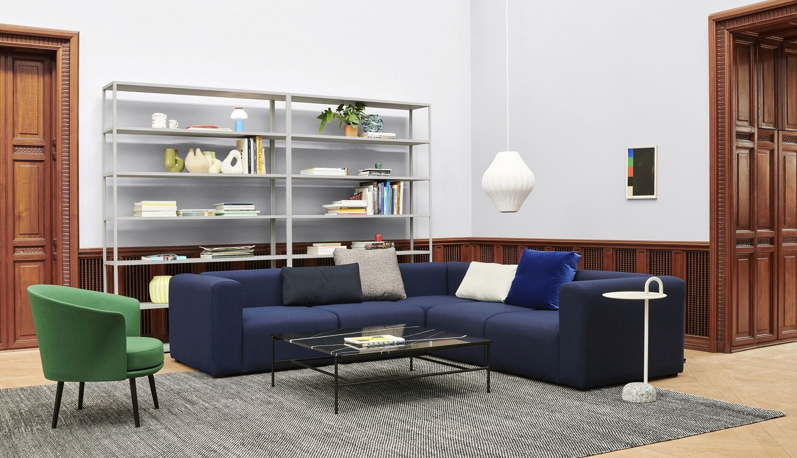 Heller Wohnraum mit blauem Ecksofa, Couchtisch, Bücherregal und Hay Bowler Beistelltisch mit Marmorfuß.
