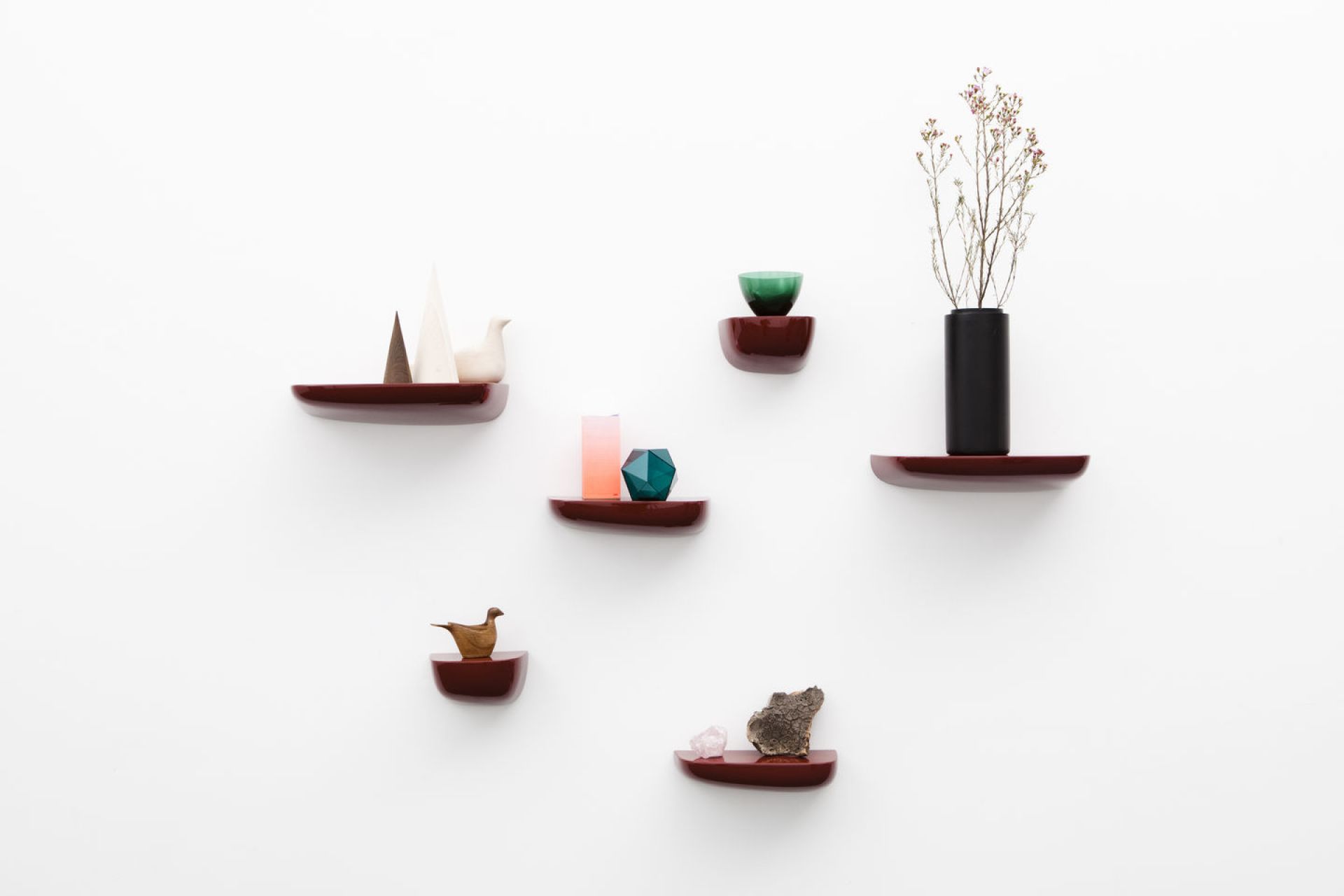 Wandansicht mit mehreren Corniches Wandboards von Vitra in Rotbraun, dekoriert mit Vasen und Figuren.