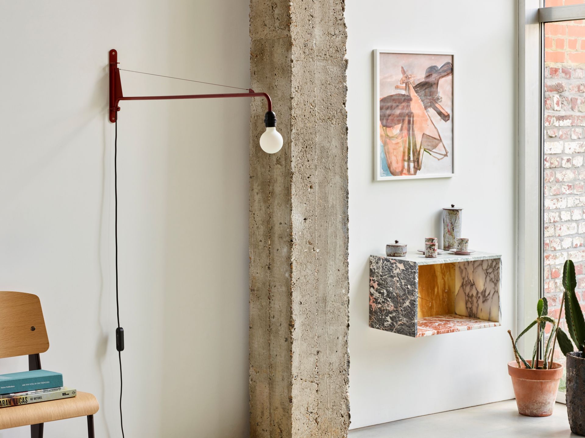Rote Petite Potence Wandleuchte von Vitra im modernen Interieur mit Betonpfeiler und Kunst.