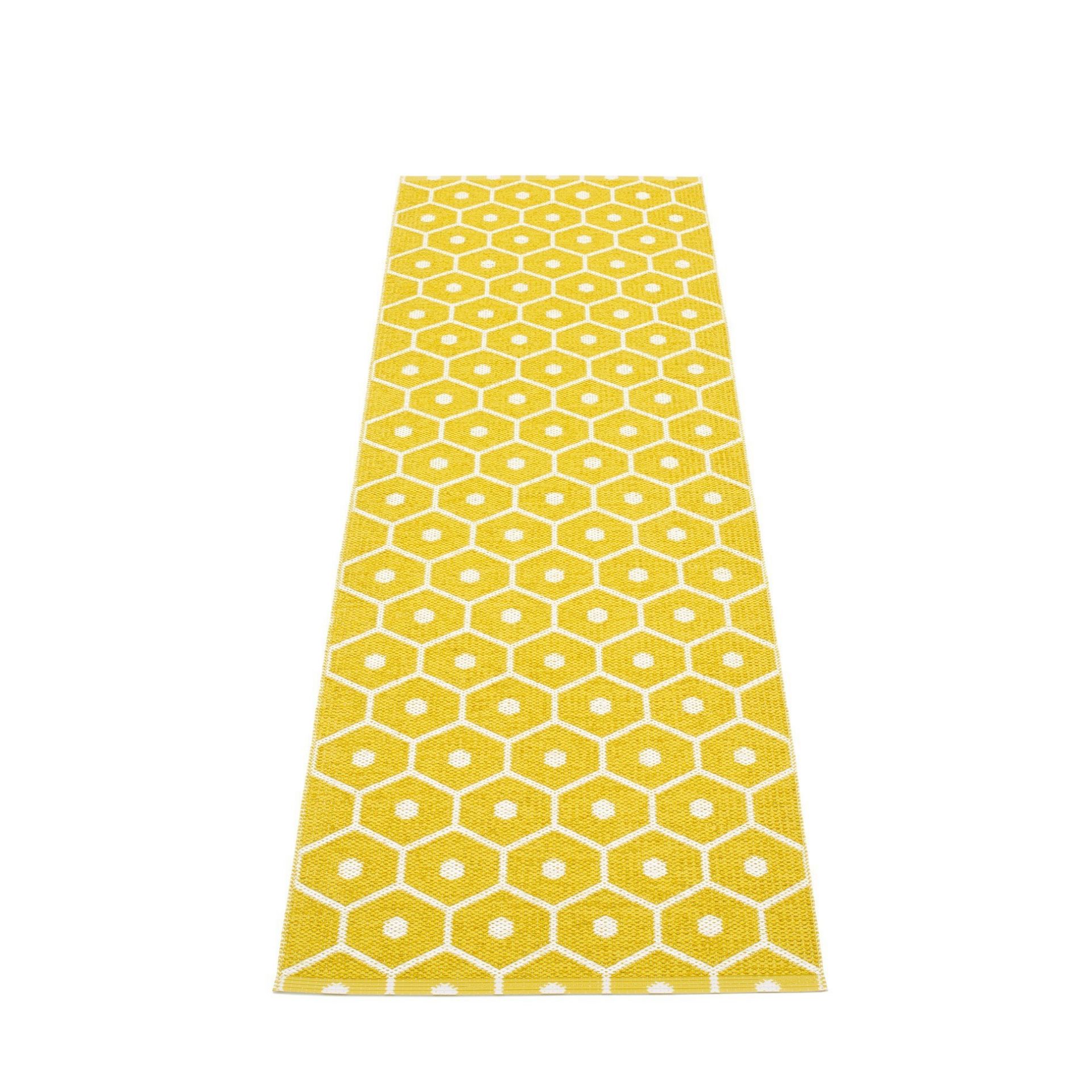Pappelina Honey Kunststoffteppich 70x225 cm mit gelbem Wabenmuster und weißen Akzenten. Robuster Teppich für Innenräume.
