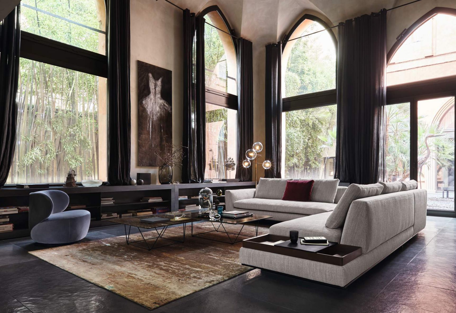 Helles Wohnzimmer mit Walter Knoll Bao Sessel, Sofa, Teppich und hohen Fenstern mit Blick ins Grüne.