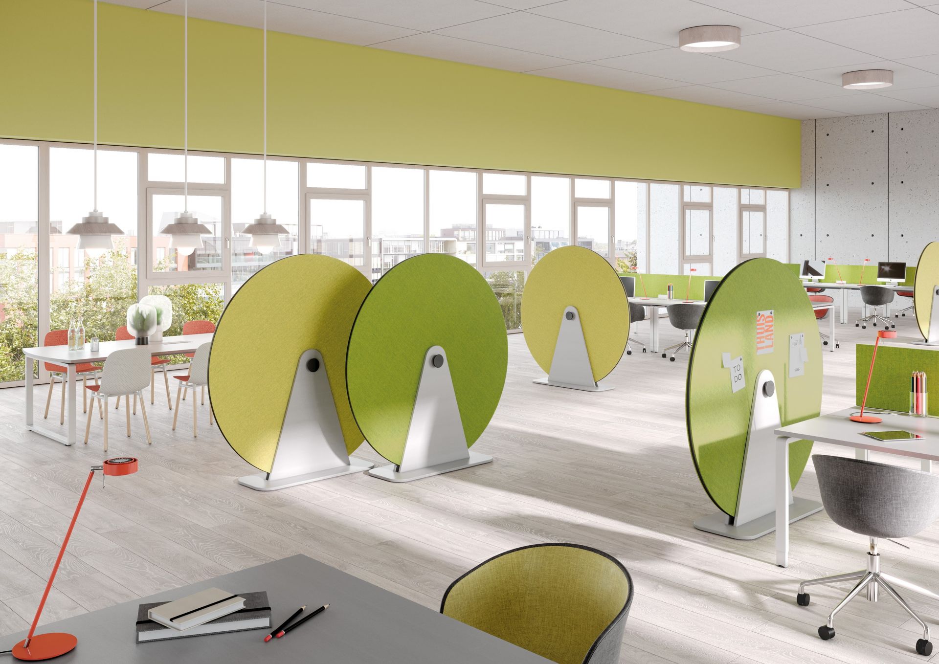 Büro mit modernen, runden Akustikpaneelen in Grün und Gelb zur Schallabsorption und als Raumteiler.
