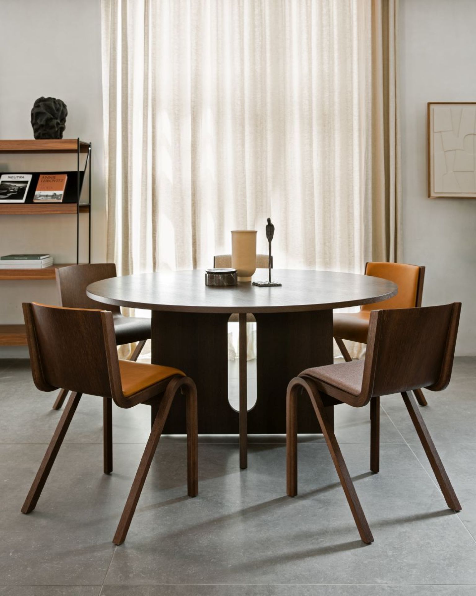 Androgyne Dining Table Esstisch Rund Audo aus dunklem Holz mit passenden Stühlen im Esszimmer.