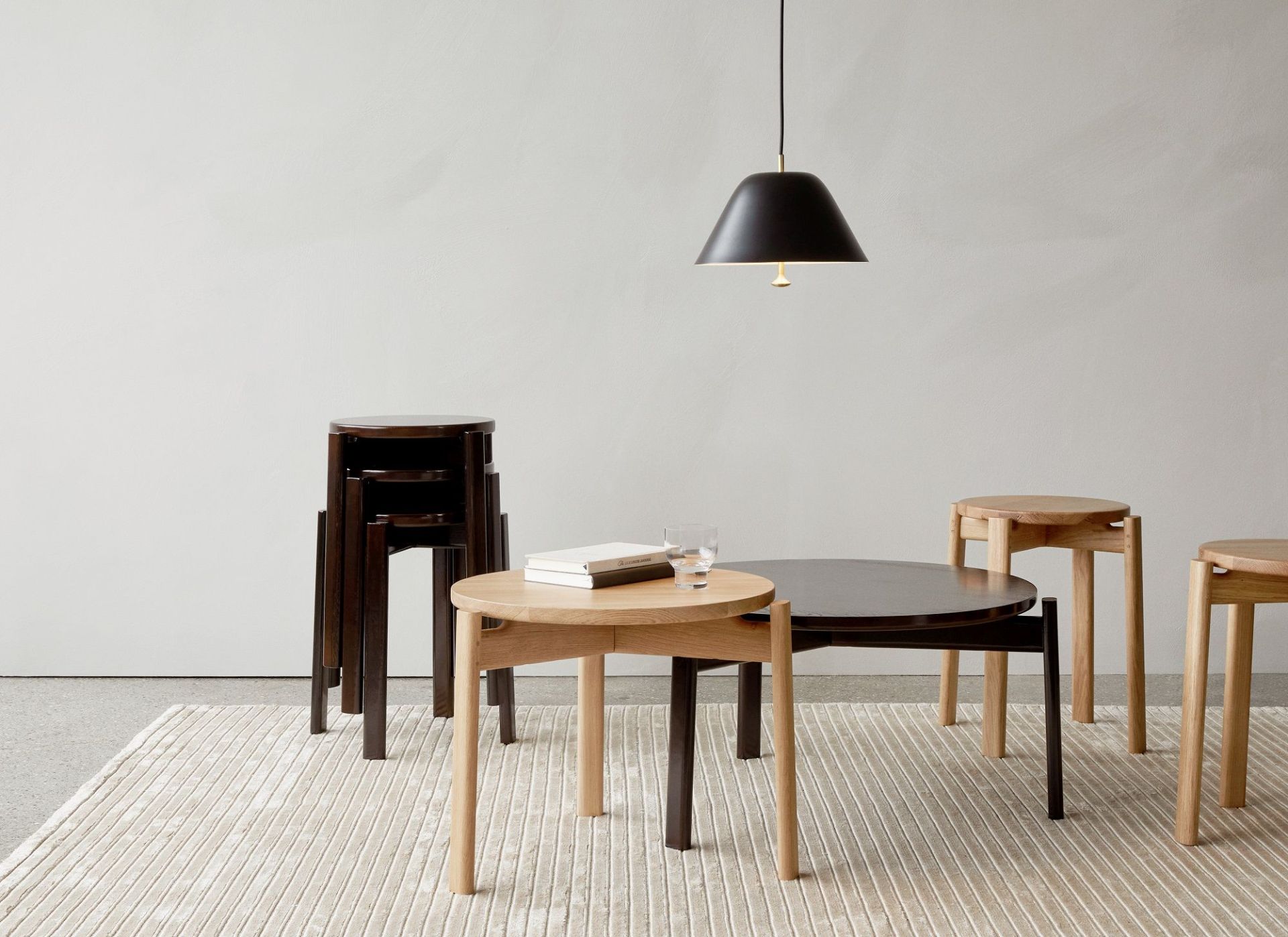 Audo Copenhagen Passage Stool Hocker aus Holz in verschiedenen Farben und Anordnungen auf Teppich.