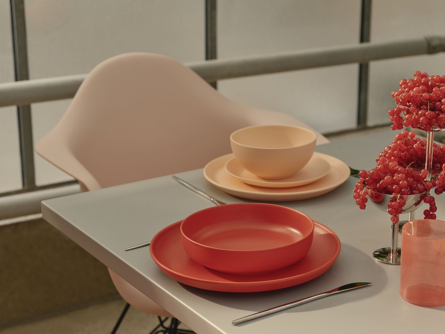 Nahaufnahme eines Eames Plastic Armchair DAR Stuhls von Vitra am Esstisch mit Geschirr.