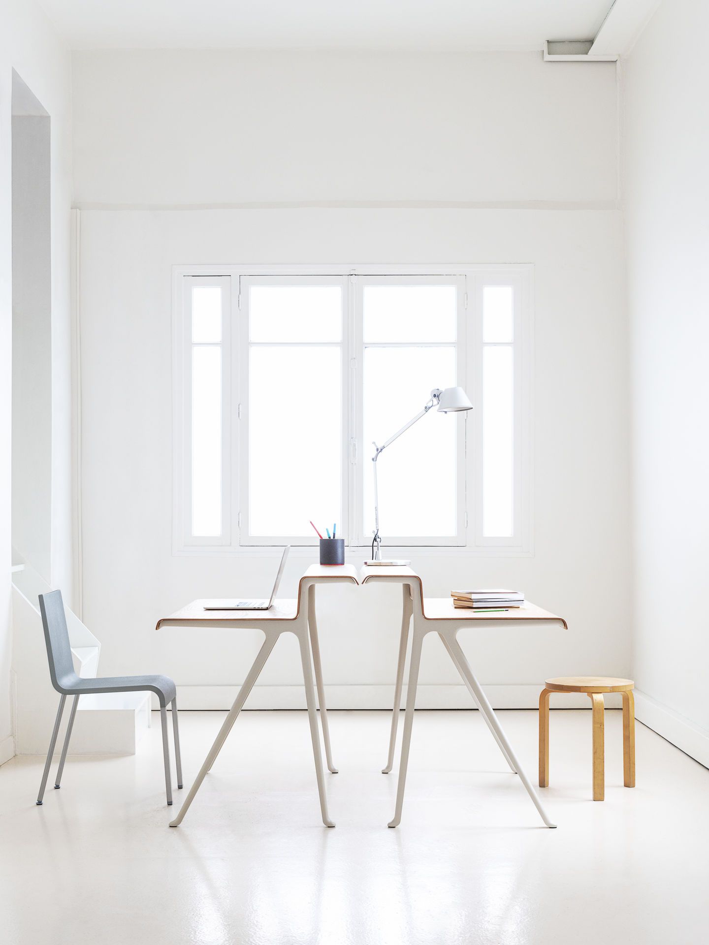 Heller Raum mit Vitra Courier Schreibtisch, Laptop, Lampe und Stuhl für modernes Homeoffice.