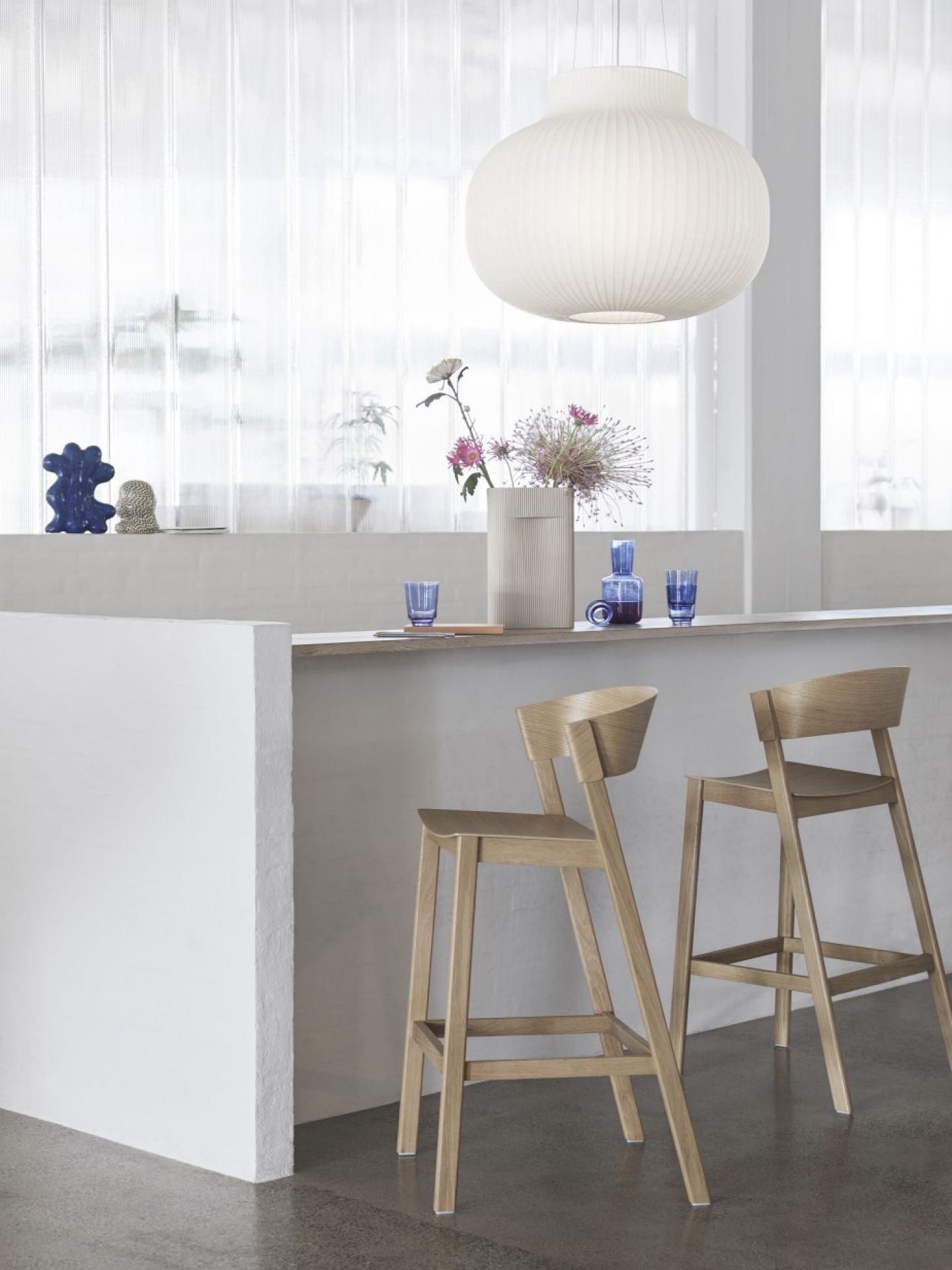 Zwei helle Cover Barstools Barhocker von Muuto aus Holz stehen an einer Küchentheke.