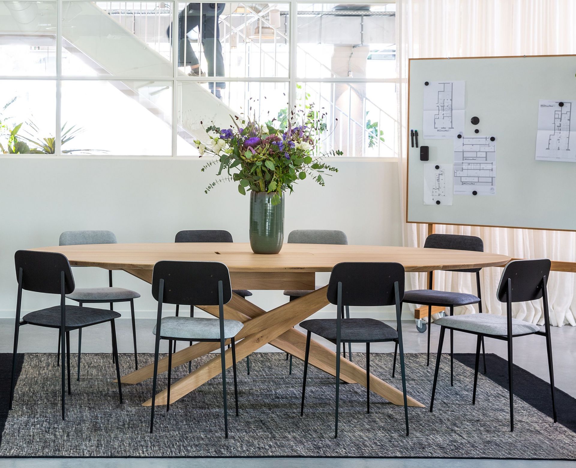 Ethnicraft Mikado Meetingtisch aus Eiche mit Stühlen in modernem Büro, ideal für Konferenzen.