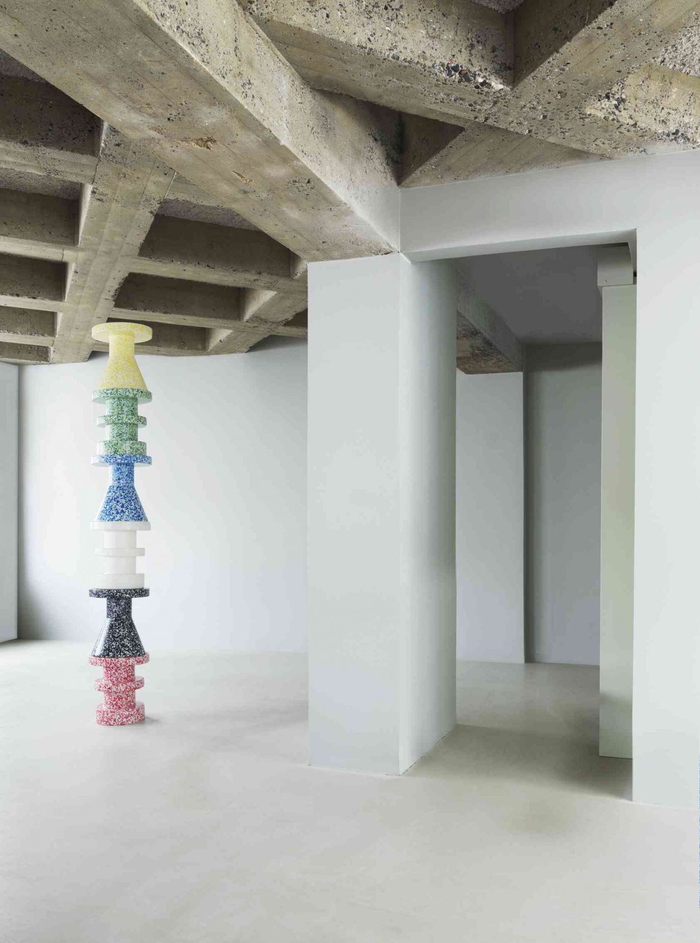 Gestapelte Bit Stool Cone Hocker von Normann Copenhagen in verschiedenen Farben im minimalistischen Raum.