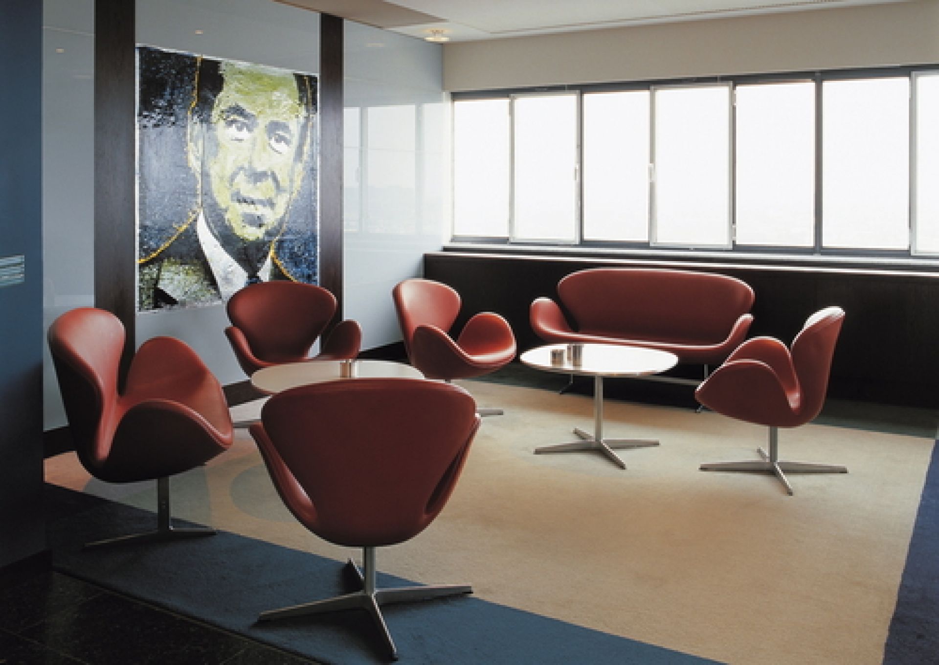 Roter Fritz Hansen Schwan Sessel und Sofa in einem modernen Büro mit Kunst an der Wand.