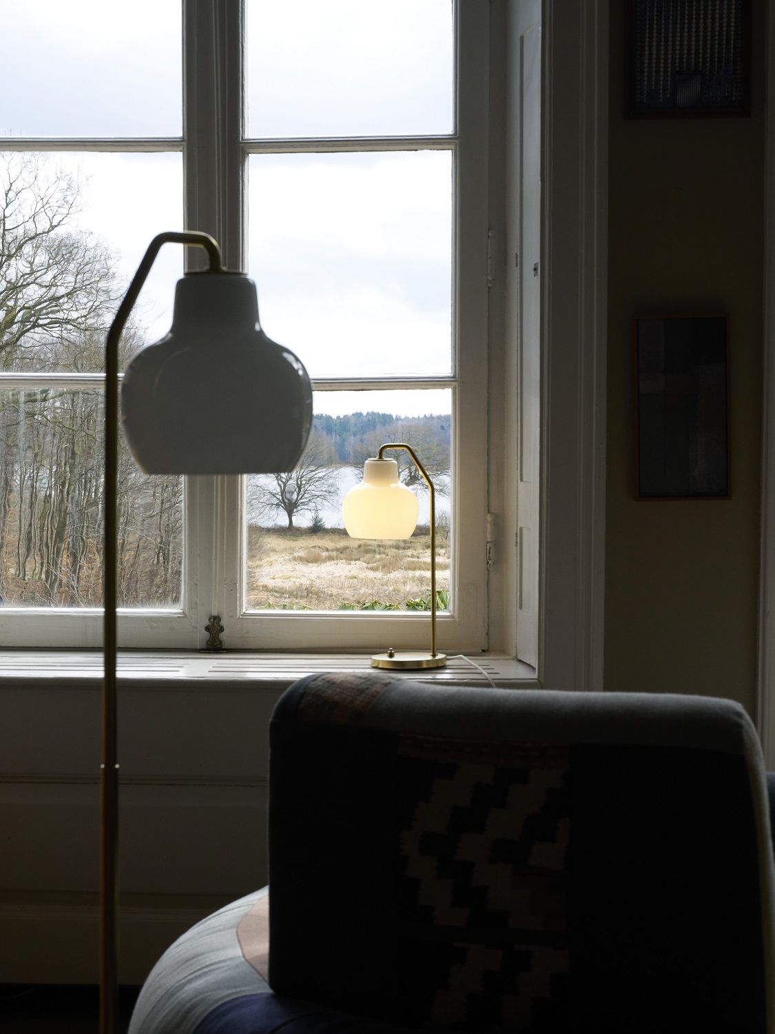 VL Ring Crown Stehleuchte von Louis Poulsen neben einem Fenster mit Blick auf einen See.
