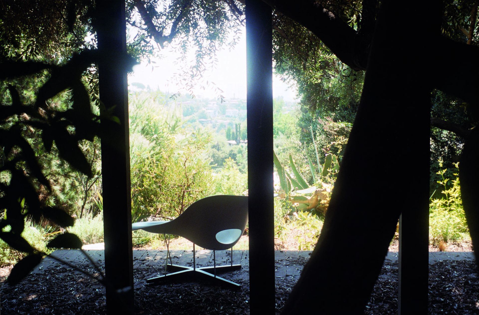 Vitra La Chaise Liege in Weiß vor Gartenkulisse, Designklassiker für stilvolles Wohnen und Entspannen.