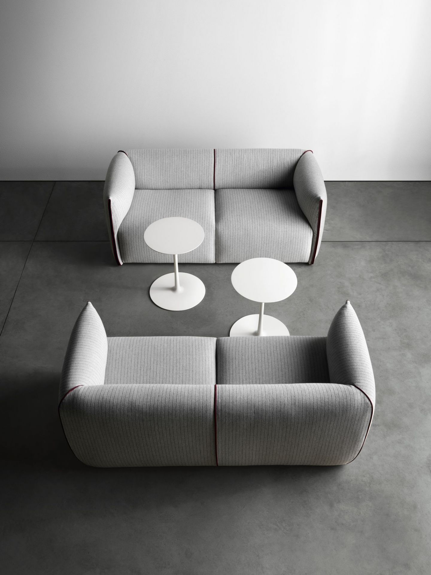 Zwei graue Sofas mit zwei weißen Flow Low Table Beistelltischen von MDF Italia im minimalistischen Ambiente.