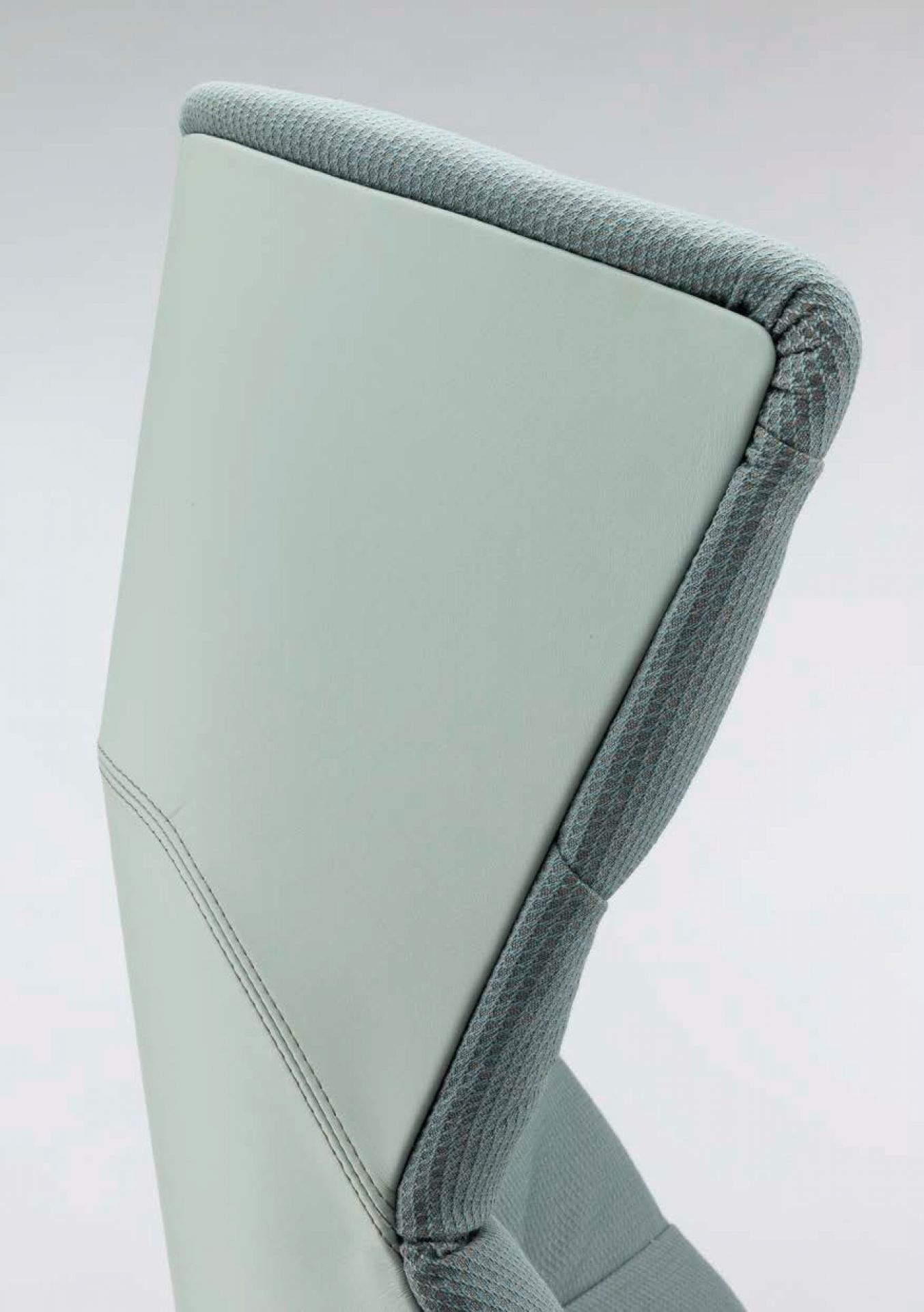 Detailaufnahme der Rückenlehne des Thonet 808 Lounge-Sessels in hellgrauem Leder und Stoffbezug.