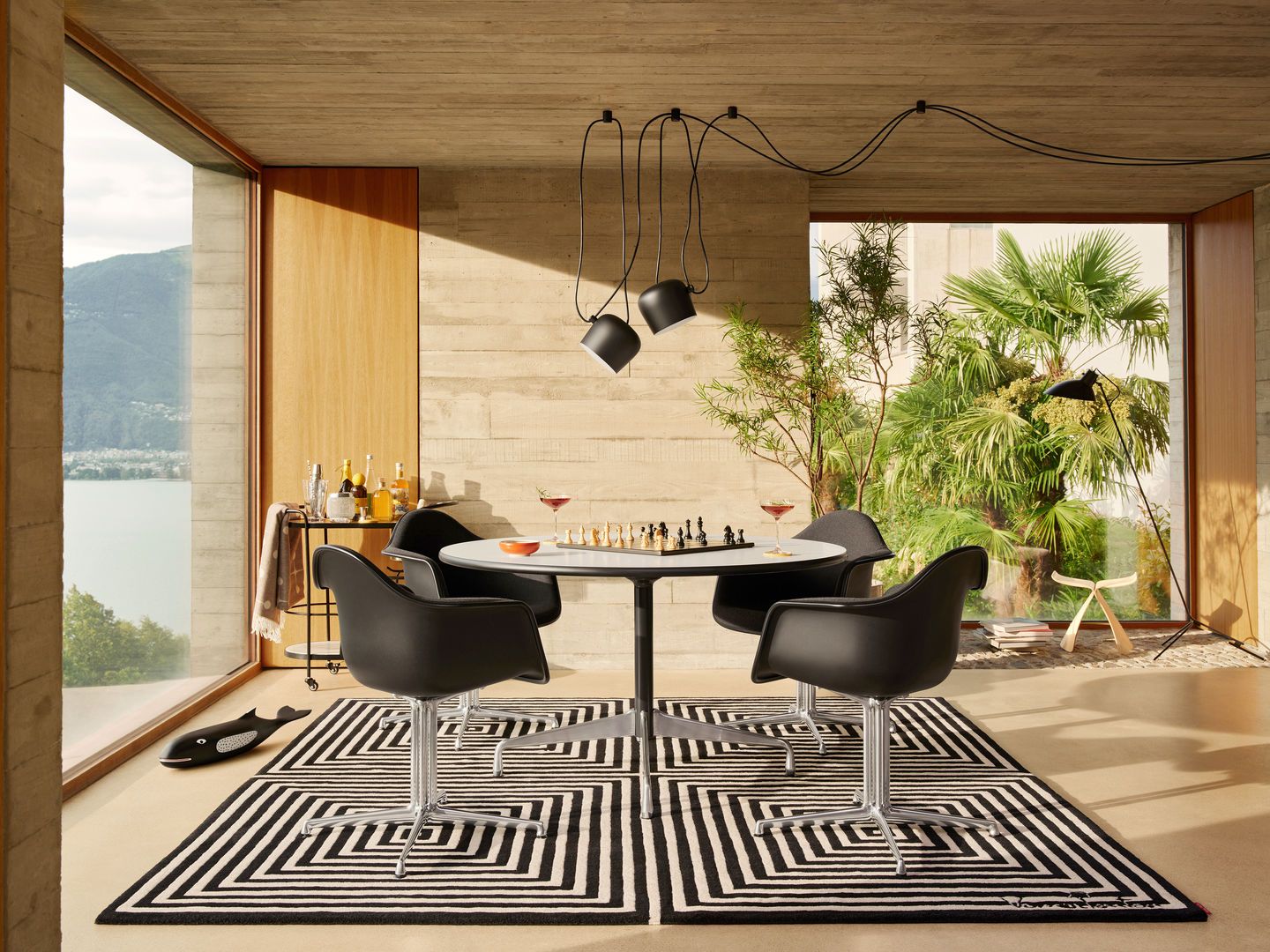Eames Plastic Arm Chair DAL mit Sitzpolster von Vitra in modernem Wohnambiente mit Schachbrett.