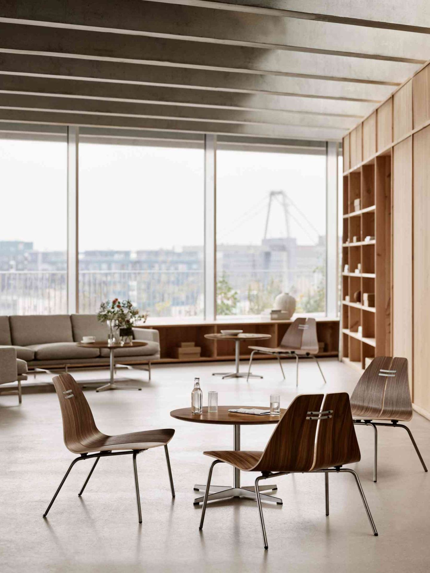 Helle Büroumgebung mit Fritz Hansen PK23 Loungesesseln aus Holz und Stahl, minimalistisches Design für modernes Wohnen.