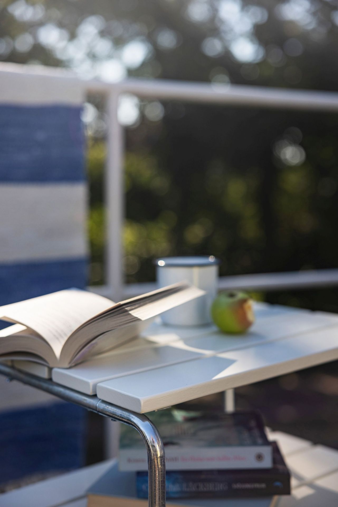 Grythyttan Stalmöbler Beistelltisch L45 Eiche: Buch, Apfel und Tasse auf dem stilvollen Gartentisch.