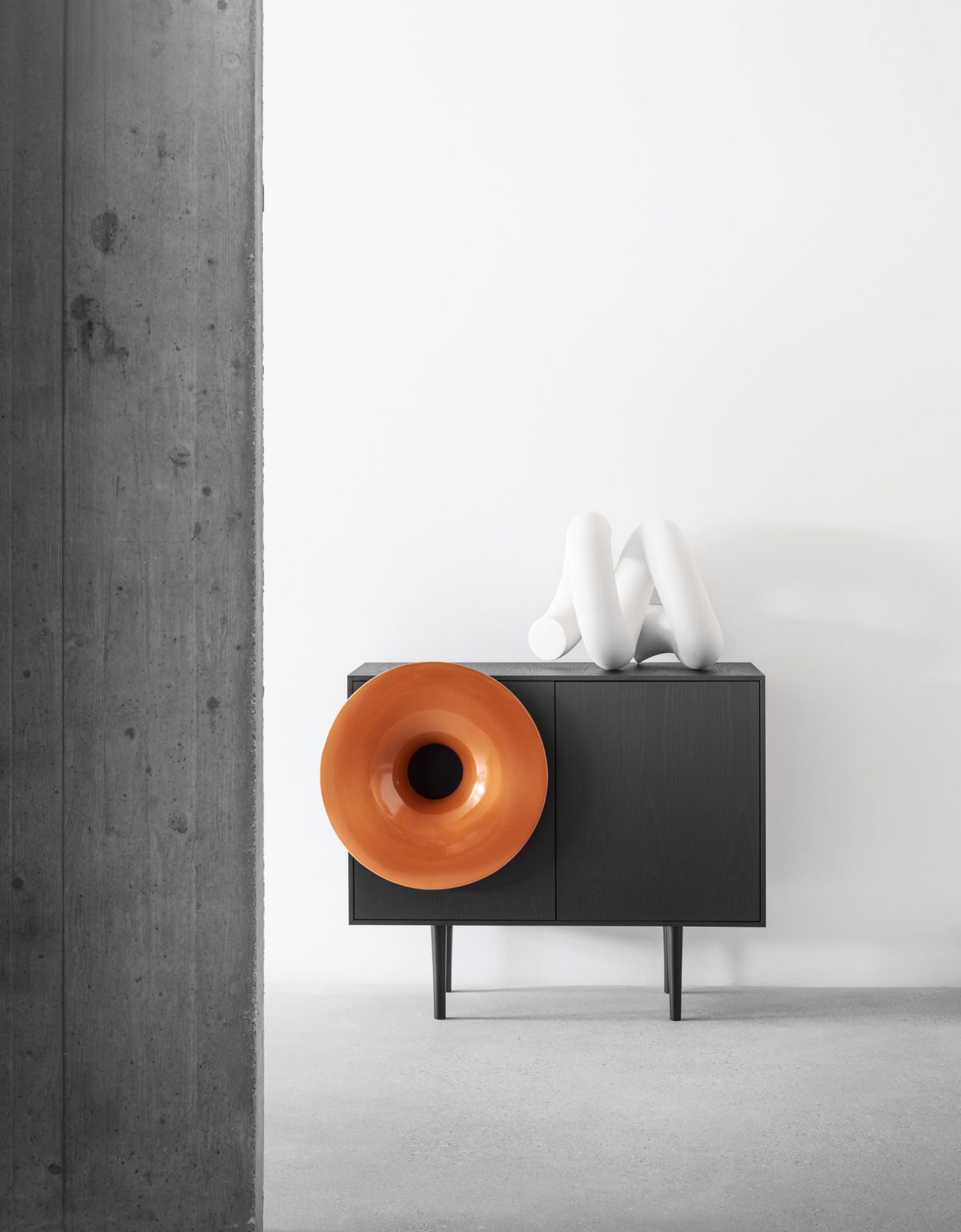 Caruso Anrichte von Miniforms in Schwarz mit orangefarbenem Lautsprecher und weißer Deko.