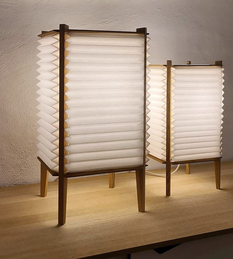 Zwei BEE HIVE Tischleuchten von Le Klint mit plissiertem Lampenschirm und Holzgestell.