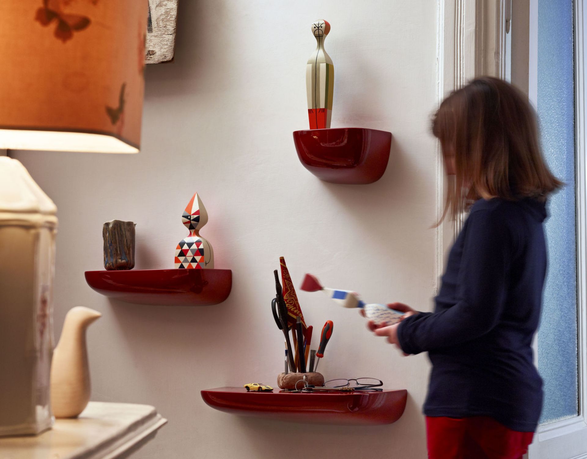 Rote Corniches Wandboards von Vitra an einer weißen Wand mit Dekoration und einer Person.