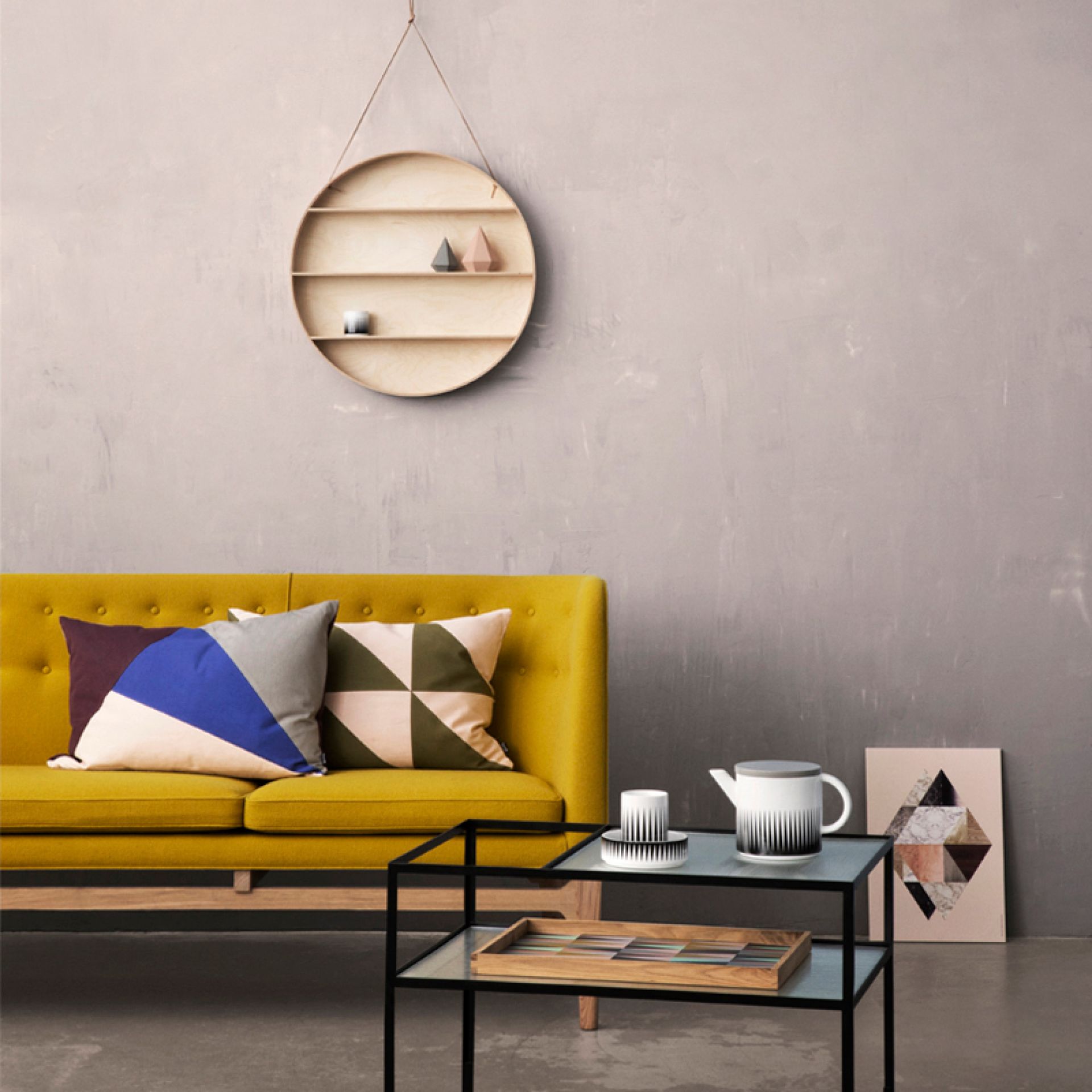 The Round Dorm Hängeregal von Ferm Living aus Holz, an einer grauen Wand hängend.