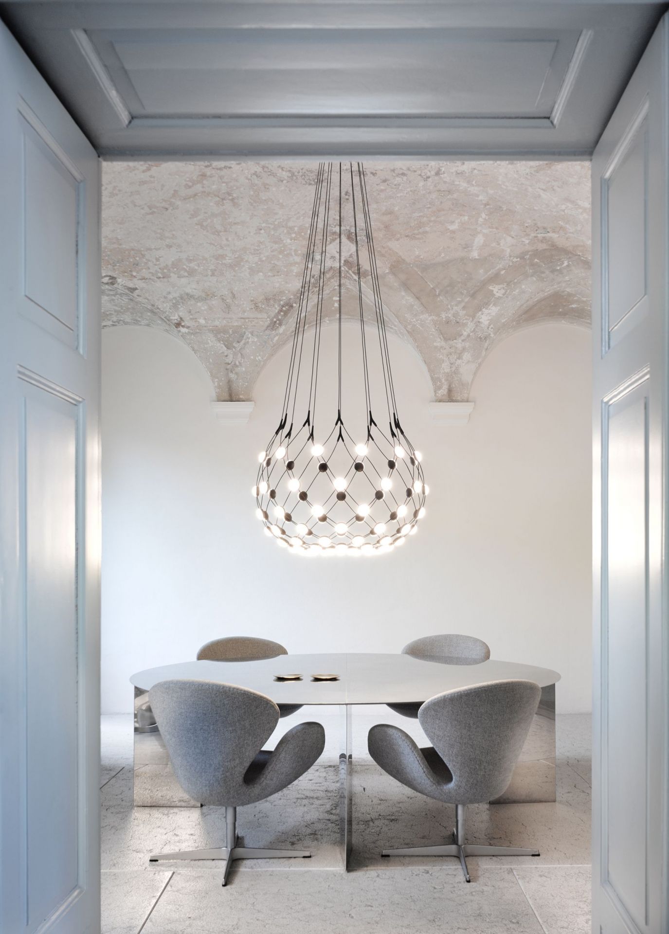 Luceplan D86 Mesh Deckenleuchte über Esstisch mit grauen Stühlen in modernem Interieur.
